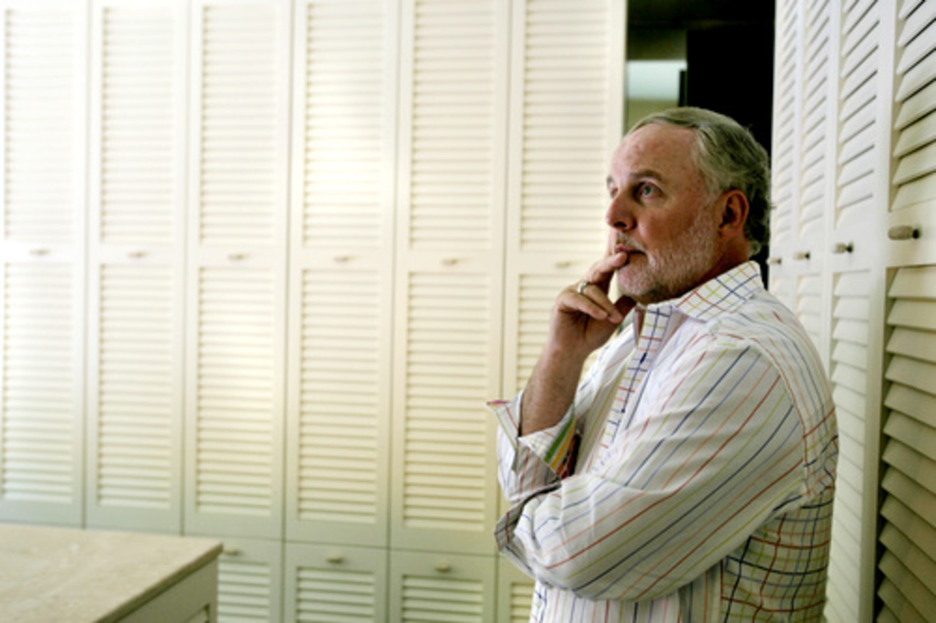 The plantation shutters surrounding Pearson in the large dressing room conceal storage areas. The room also includes a dressing table and a lighted vanity.