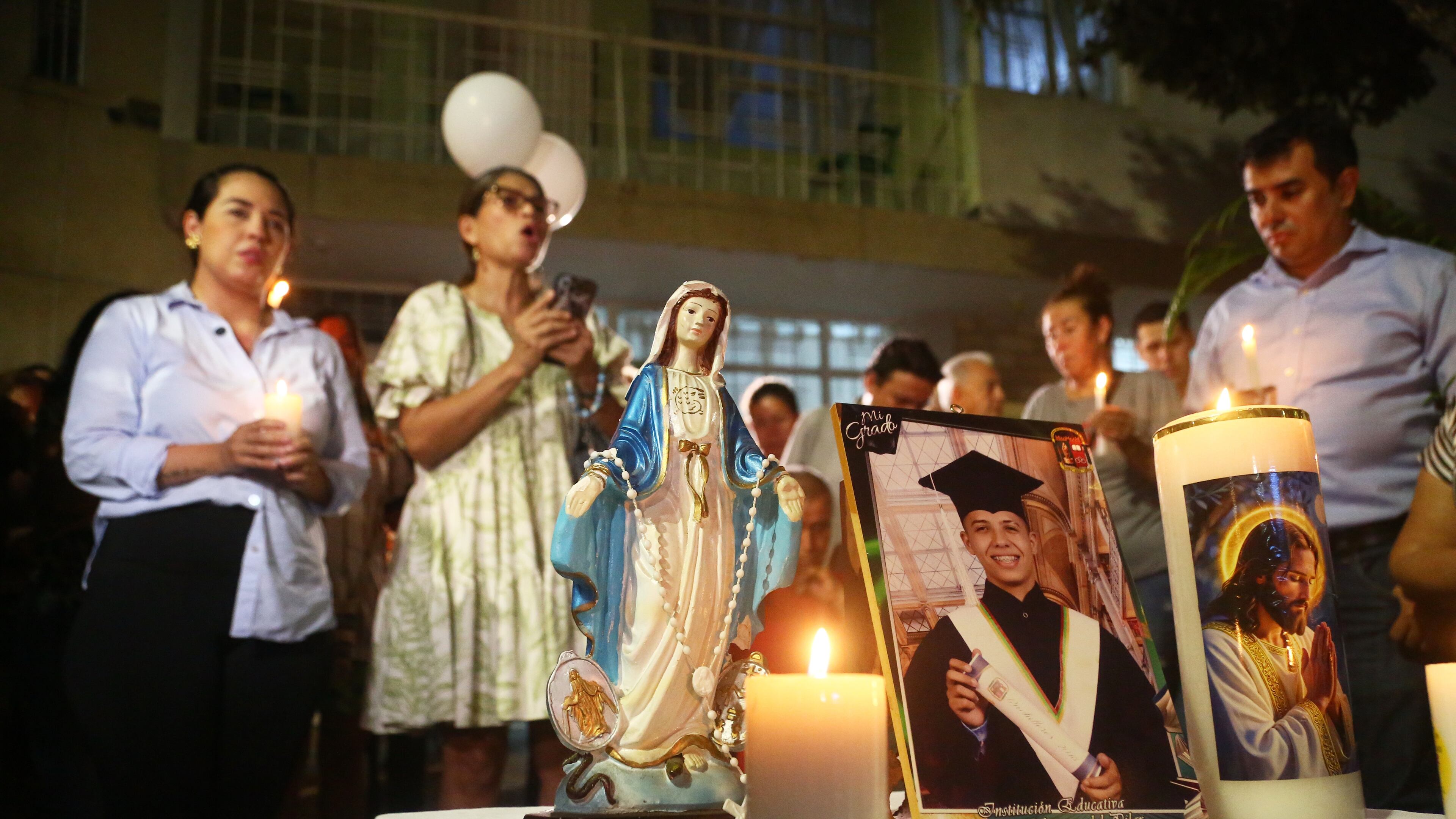 Friends and relatives hold a vigil for Johan Sebastián Durán Guerrero, a Colombian national who was fatally shot by an Immigration and Customs Enforcement officer in Maine, at his family home in Bucaramanga, Colombia, Tuesday, July 14, 2026. (AP Photo/Jaime Moreno)
