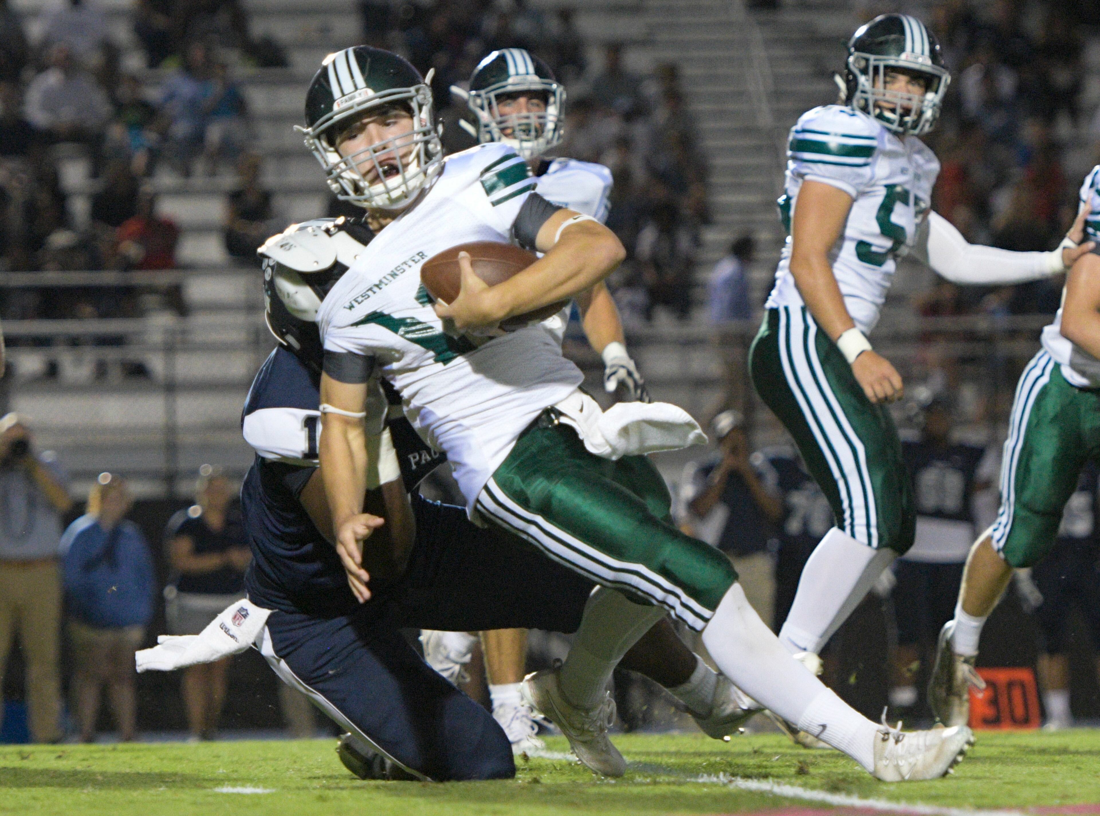 Westminster QB Chance Loeffler is brought down by Pace Academy DE Jaquari Wiggles during their high school football game Oct. 6, 2017, in Atlanta. (Special for the Atlanta Journal Constitution/John Amis)