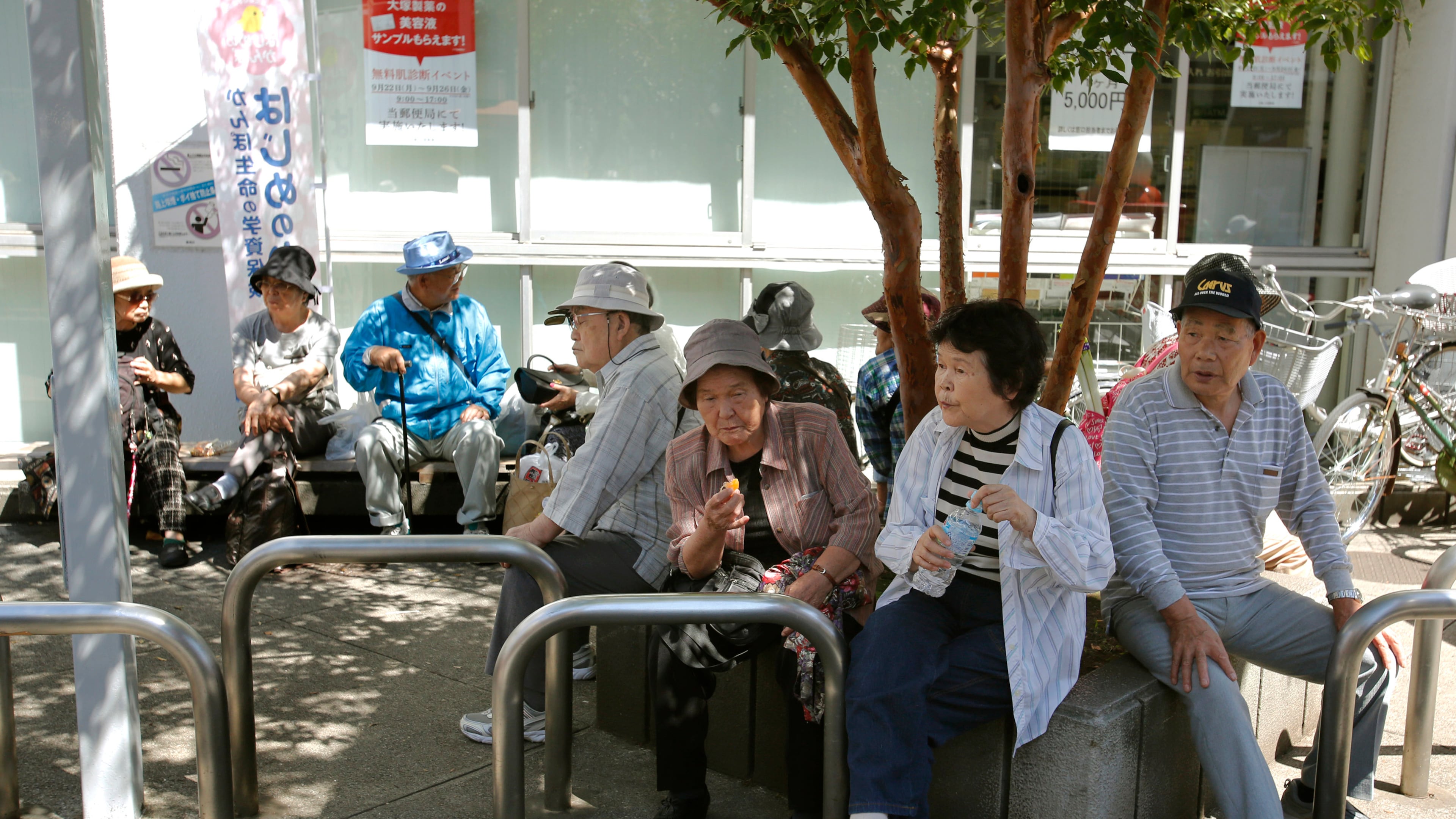 Elderly people rest under the shade of a tree in Tokyo, Sunday, Sept. 14, 2014. (AP Photo/Shizuo Kambayashi, File)