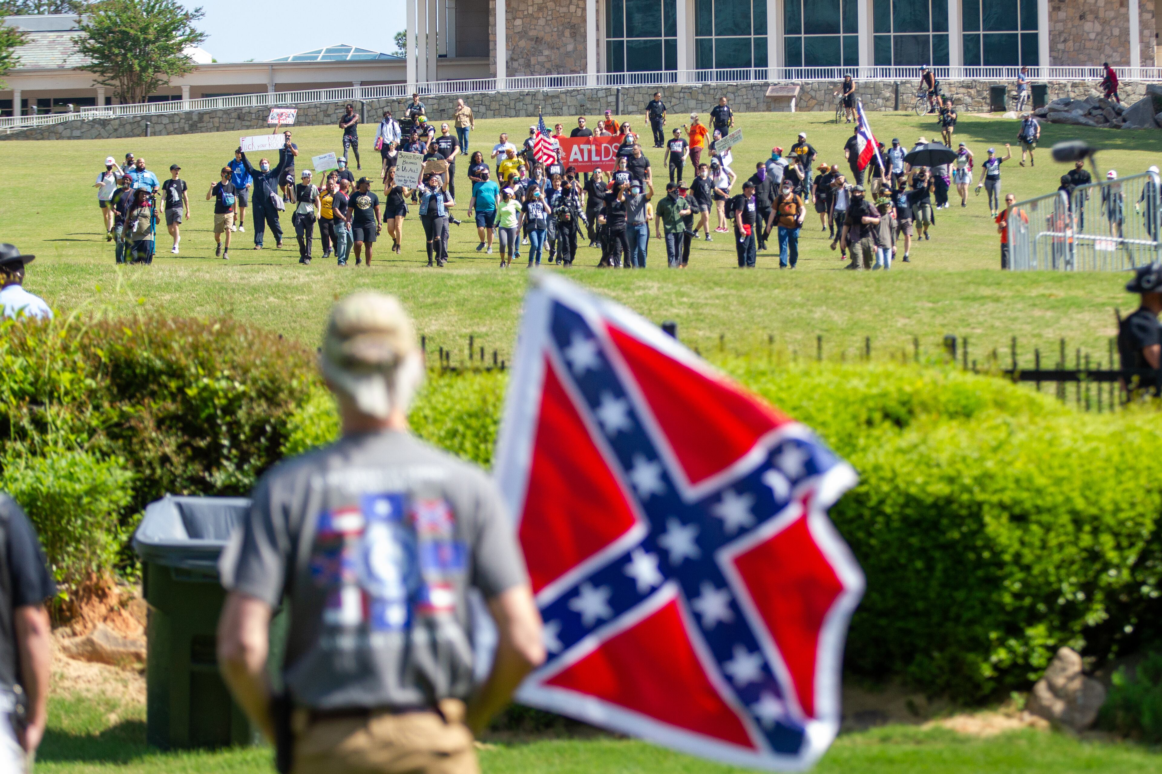 Members of the Sons of Confederate Veterans were met by counterprotesters - the two sides separated by a fence - during a rally to mark Confederate Memorial Day at Stone Mountain Park on Saturday, April 30, 2022. (Photo: Steve Schaefer / steve.schaefer@ajc.com)