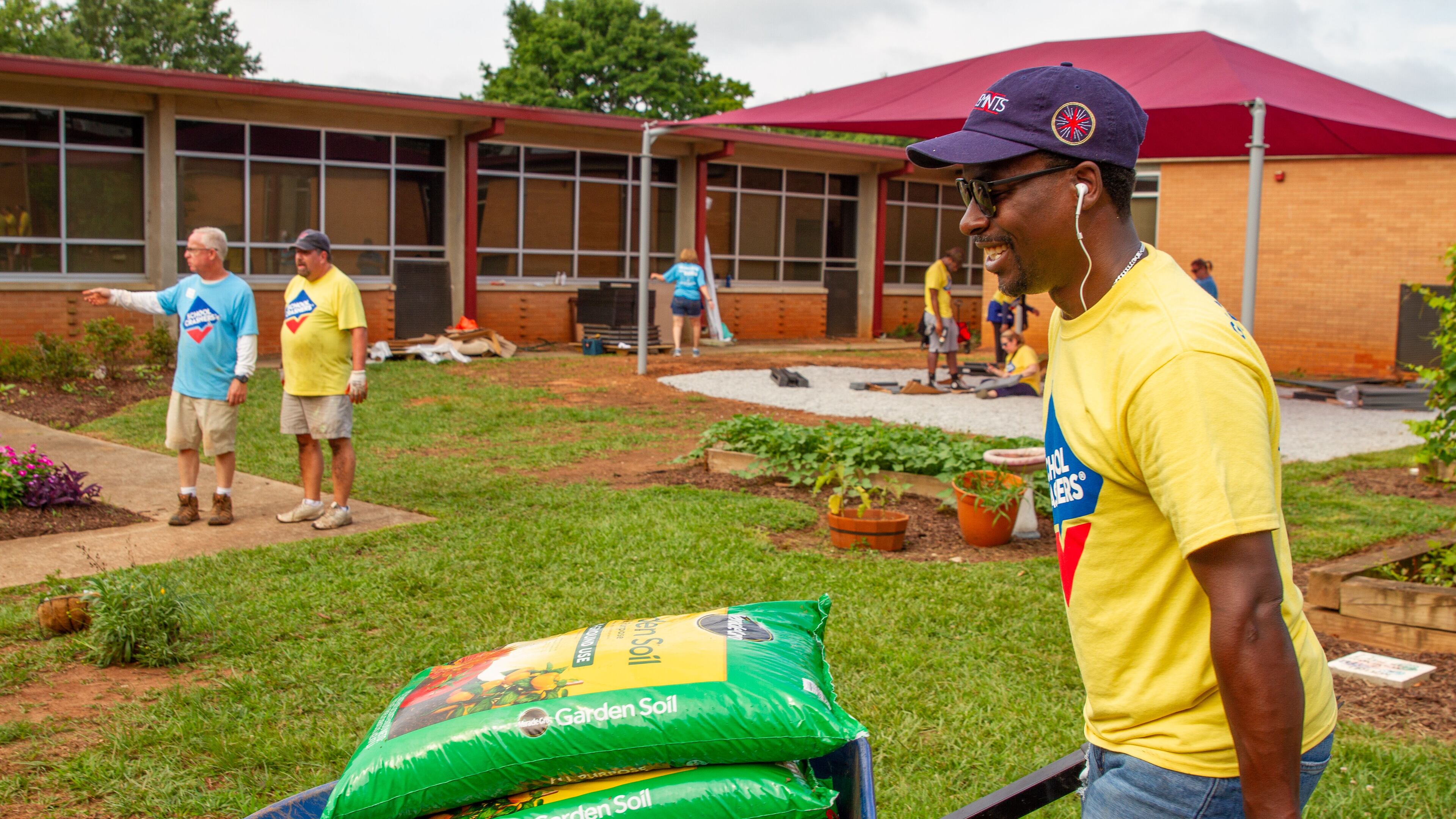 DeKalb County School District Vice Chair Diijon DaCosta moves bags of soil at the Georgia United Foundation/Georgia United Credit Union’s School Crashers makeover event at Towers High School.