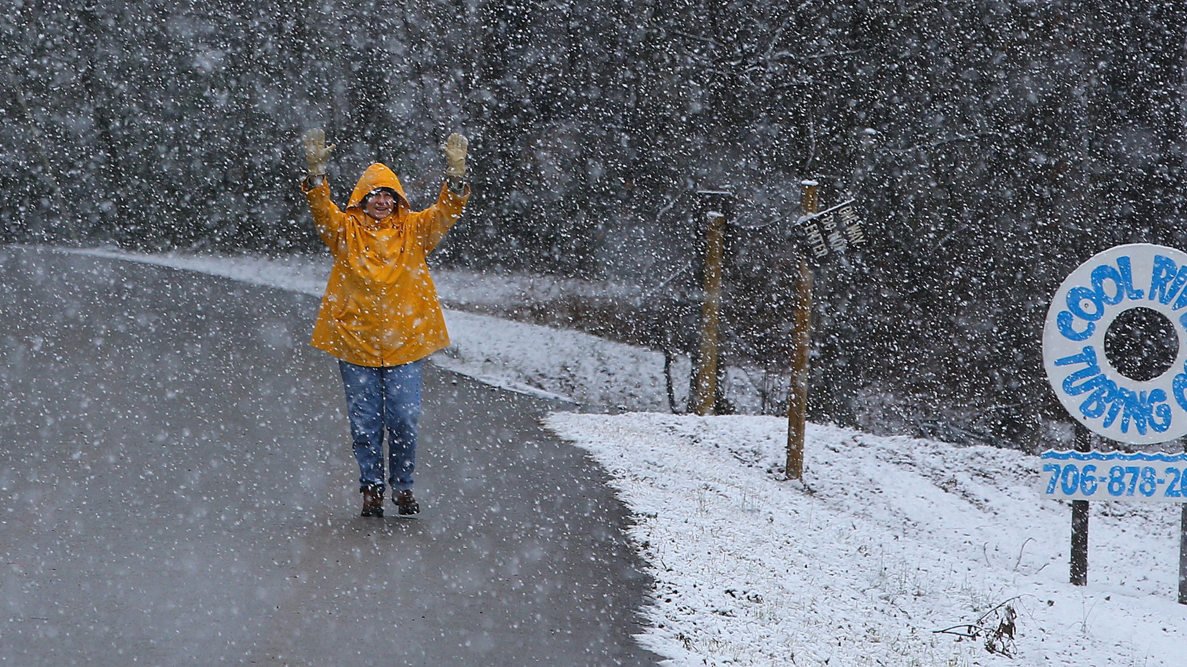 Local resident Linda Thomason plays in the heavy snow fall while taking a walk on Popular Stump Road near her home on Tuesday, Feb. 11, 2014, in Helen. CURTIS COMPTON / CCOMPTON@AJC.COM