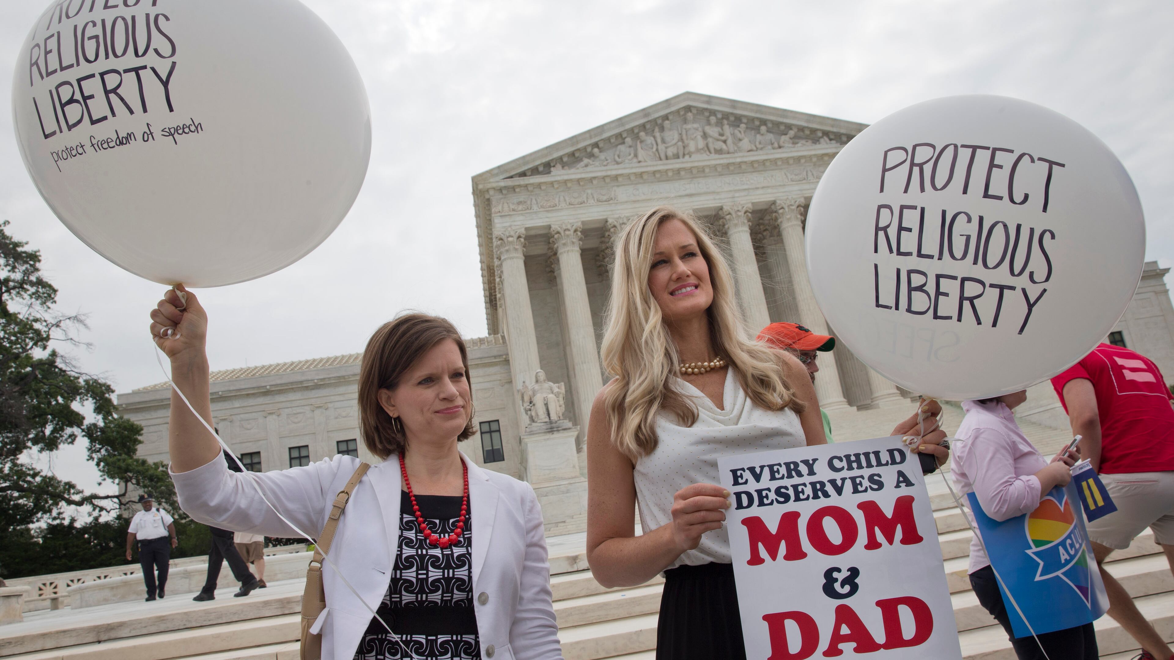 Jennifer Marshall, with the Heritage Foundation, and Summer Ingram, with the Congressional Prayer Caucus Foundation, who said they support "traditional marriage" hold balloons that says "protect religious liberty" outside of the Supreme Court Friday June 26, 2015, in Washington, before the court declared that same-sex couples have a right to marry anywhere in the US. (AP Photo/Jacquelyn Martin)