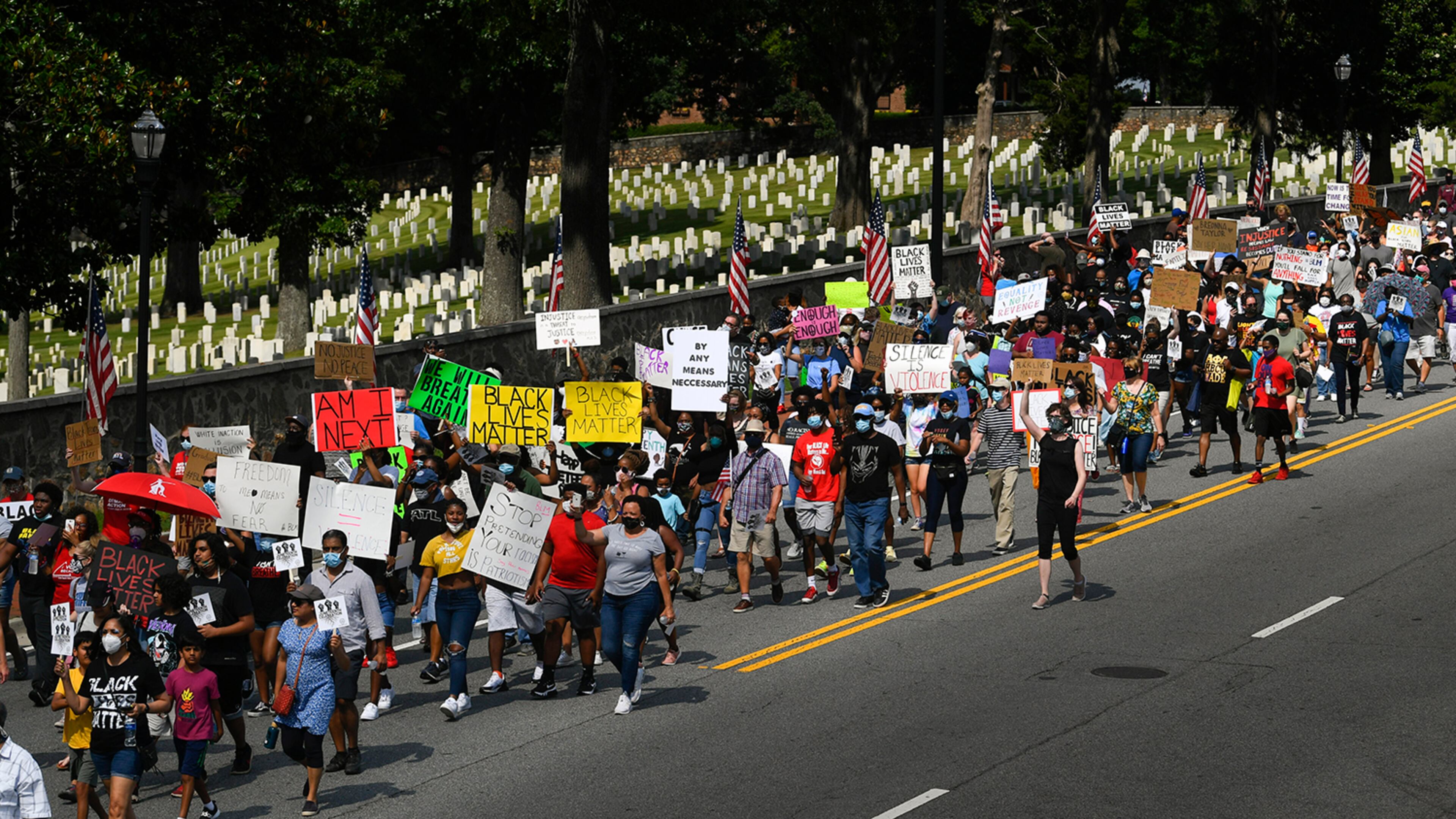 Marchers make their way past the National Park Services civil war cemetery from the Cobb NAACP offices to Marietta Square during a demonstration to commemorate Juneteenth on Friday June 19, 2020, in Marietta. JOHN AMIS FOR THE ATLANTA JOURNAL-CONSTITUTION
