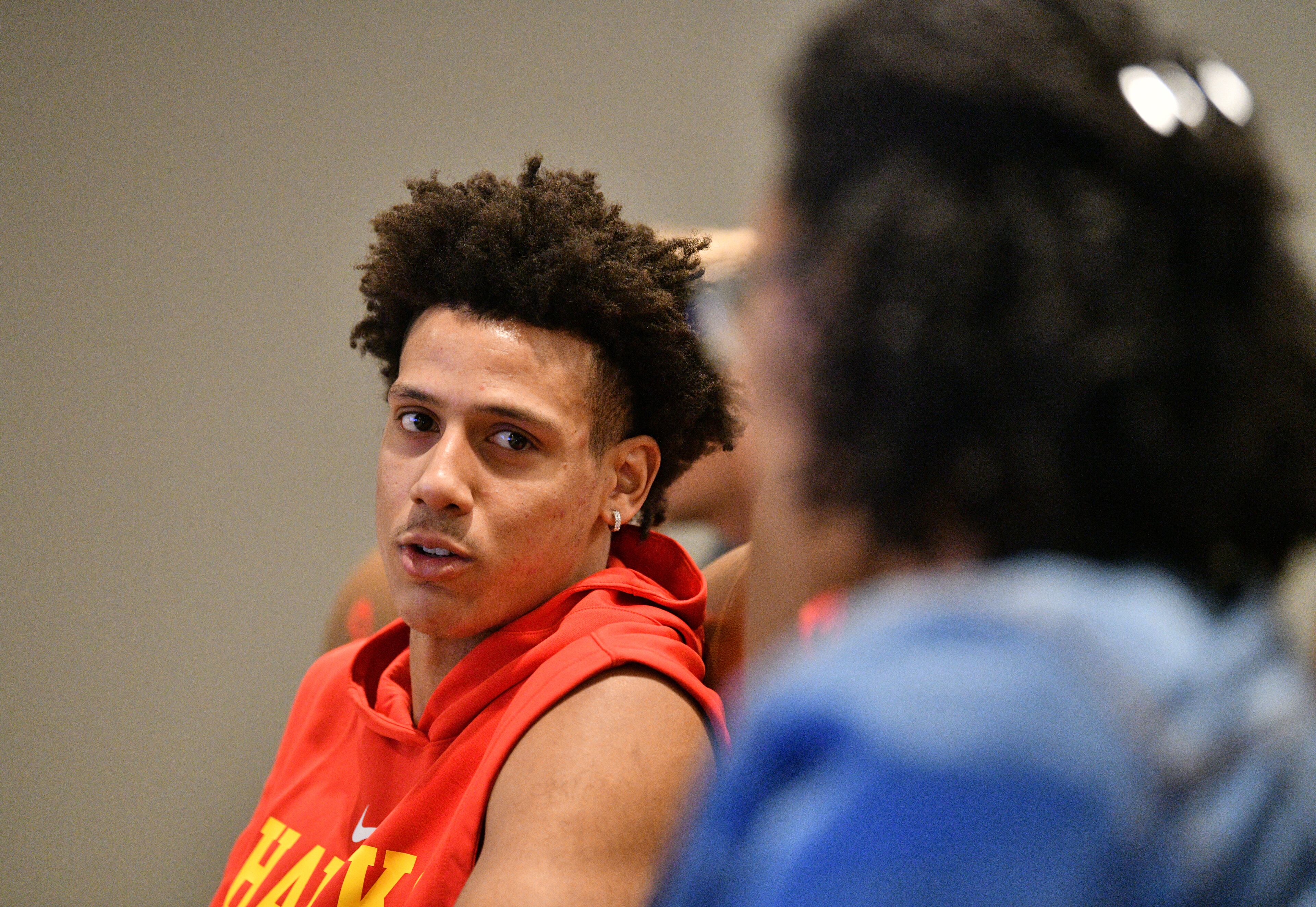 Atlanta Hawks forward Jalen Johnson, who did not make the trip, reacts as he watches a preseason game against Milwaukee Bucks in Abu Dabi with AJC beat reporter Lauren Williams at the team's training facility on Thursday, Oct. 6, 2022. (Hyosub Shin / Hyosub.Shin@ajc.com)