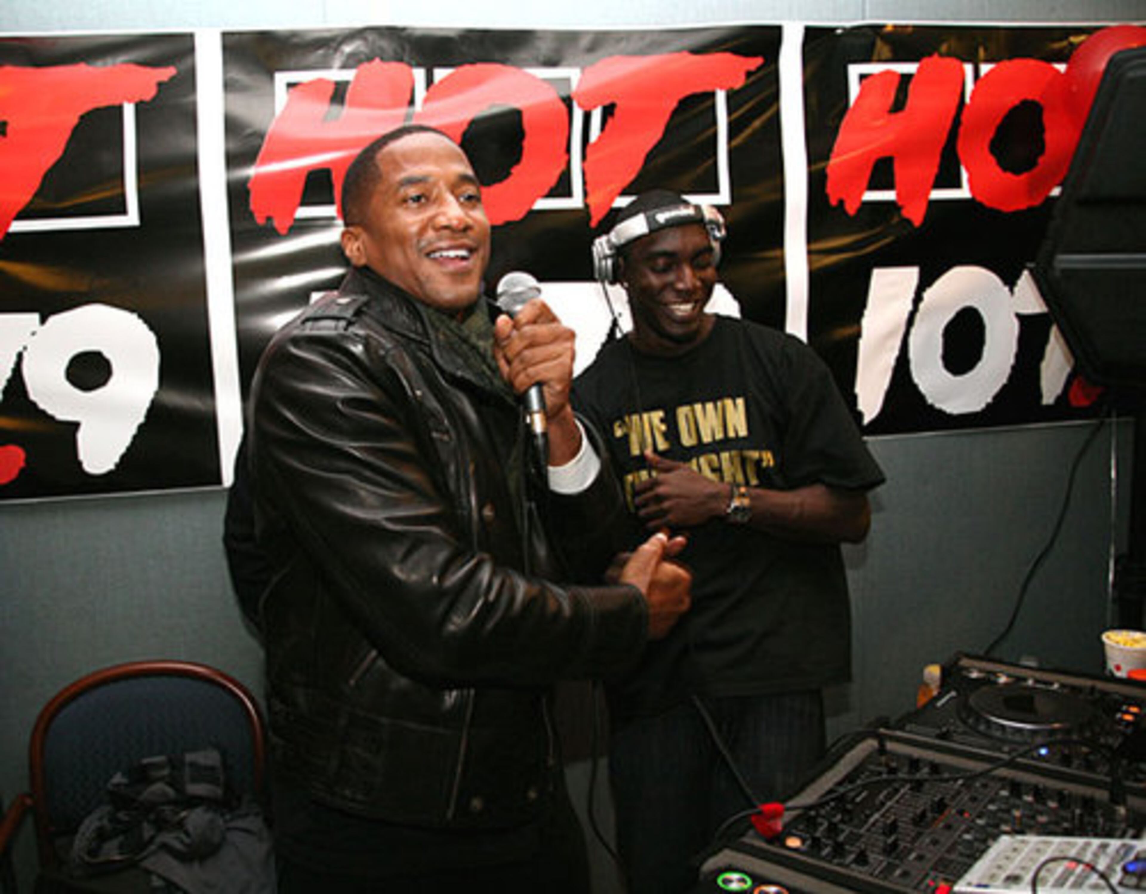 Q-Tip speaks to the large crowd in front of a Hot 107.9 sign.