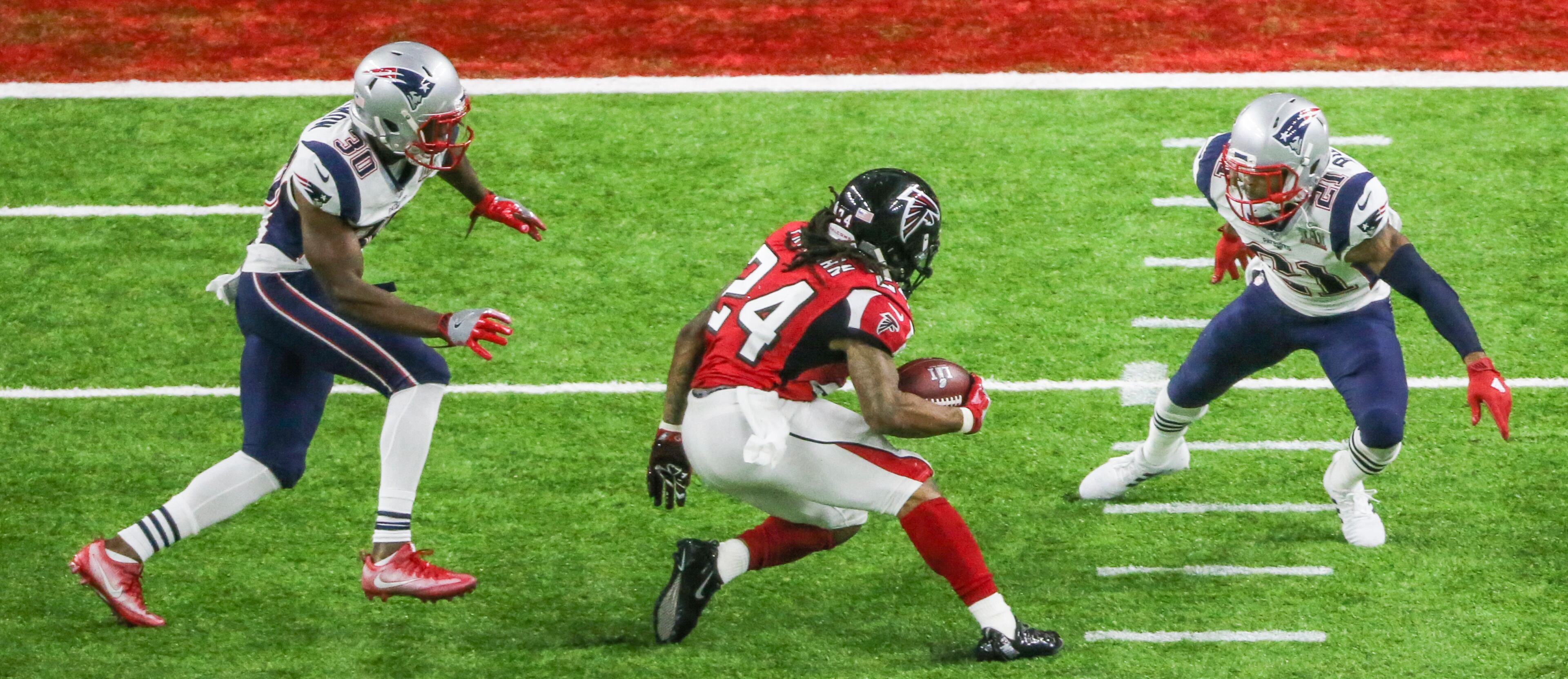 Devonta Freeman puts a move on a pair of New England defenders during Super Bowl 51.