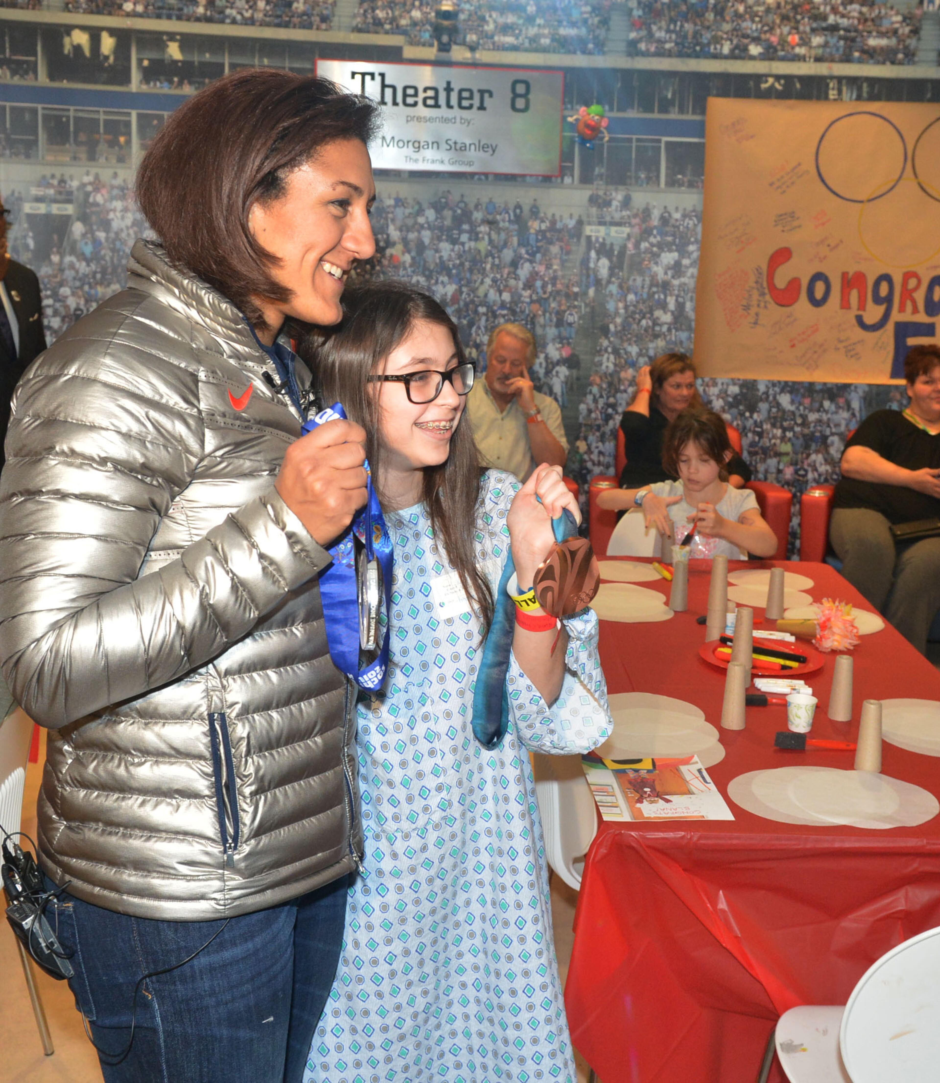 Douglasville-native Elana Meyers visits with Emerson Shuster, 14, of Johns Creek. during a visit to The Zone at Children's Healthcare of Atlanta at Scottish Rite Monday, February 24, 2014. Meyers showed the silver medal she won in the bobsled competition in Sochi, Russia on Feb. 19, becoming the first U.S. women's bobsledder to win multiple Olympic medals. KENT D. JOHNSON / KDJOHNSON@AJC.COM