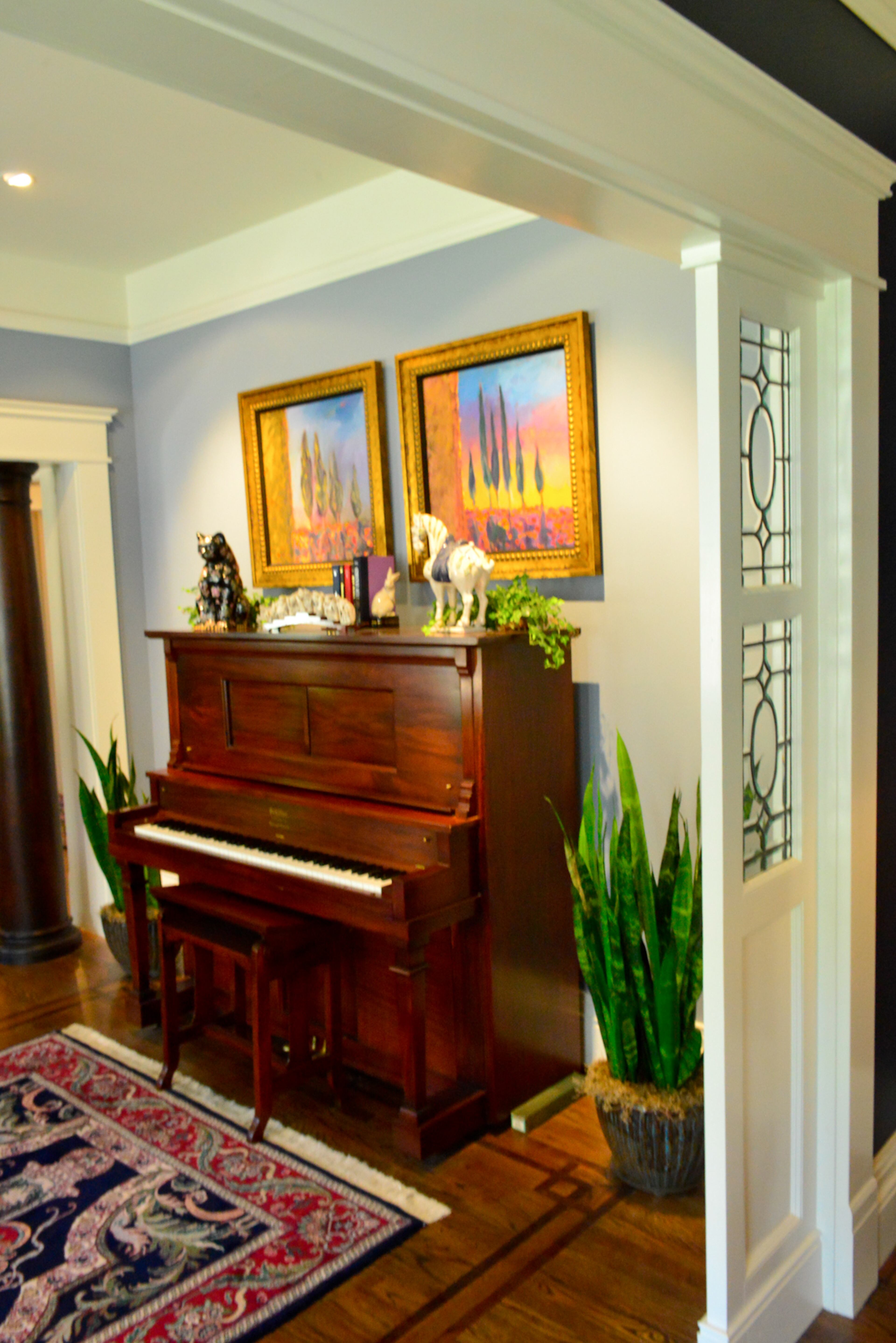 Leaded glass room dividers also are original to the 1918 home in Atlanta's Druid Hills neighborhood, and custom moldings were added in the renovation. The Boones made sure to find a place for a 1908 Schiller upright player piano, which Jim rescued from an uncle's barn and had it restored in 1992. Two Donna Pinter paintings are above the piano.