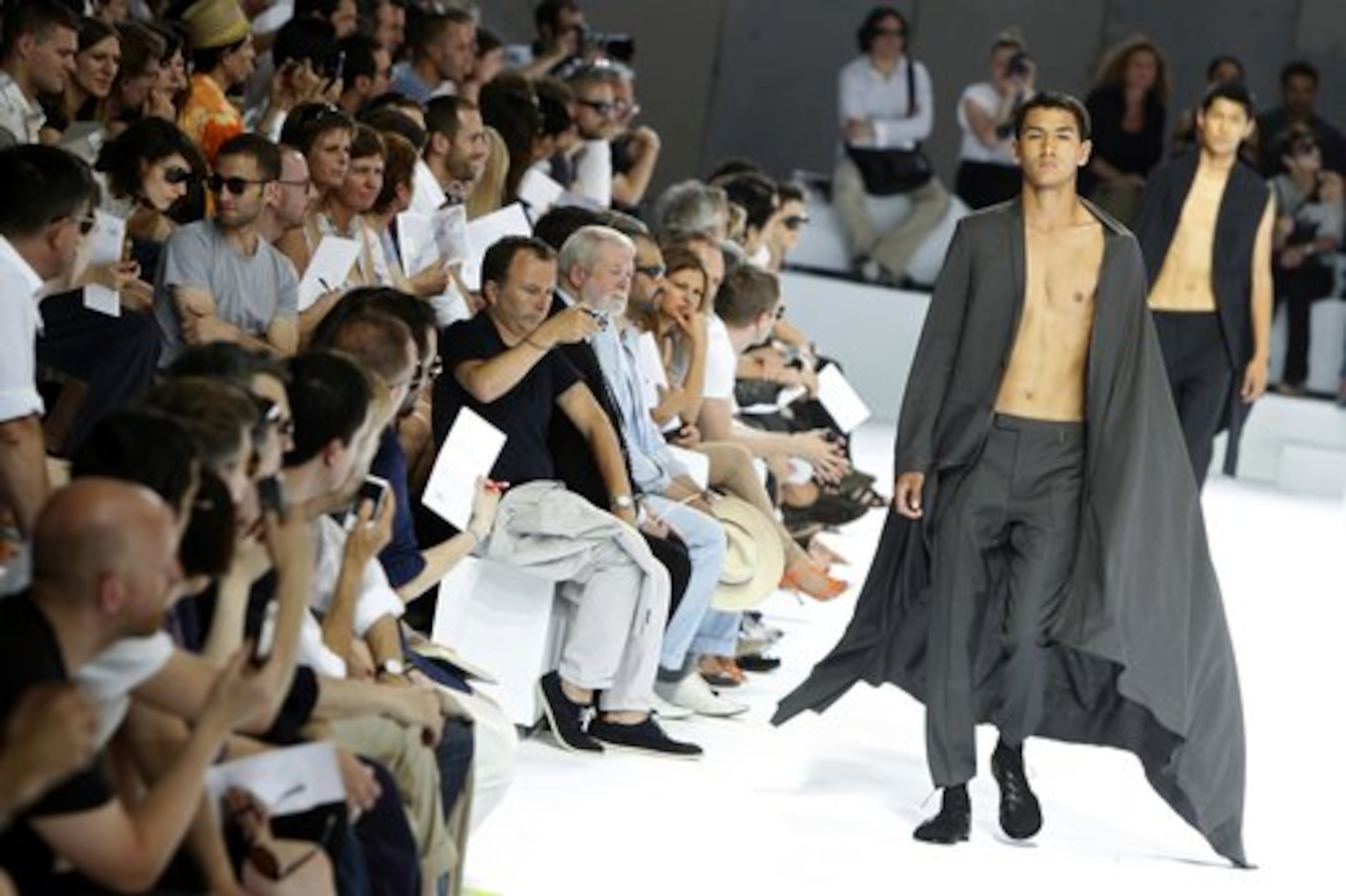 The crowd watches intently as a model wears a creation by Belgium fashion designer Kris Van Assche for Dior as part of the Men's Spring-Summer 2011 fashion collection in Paris.