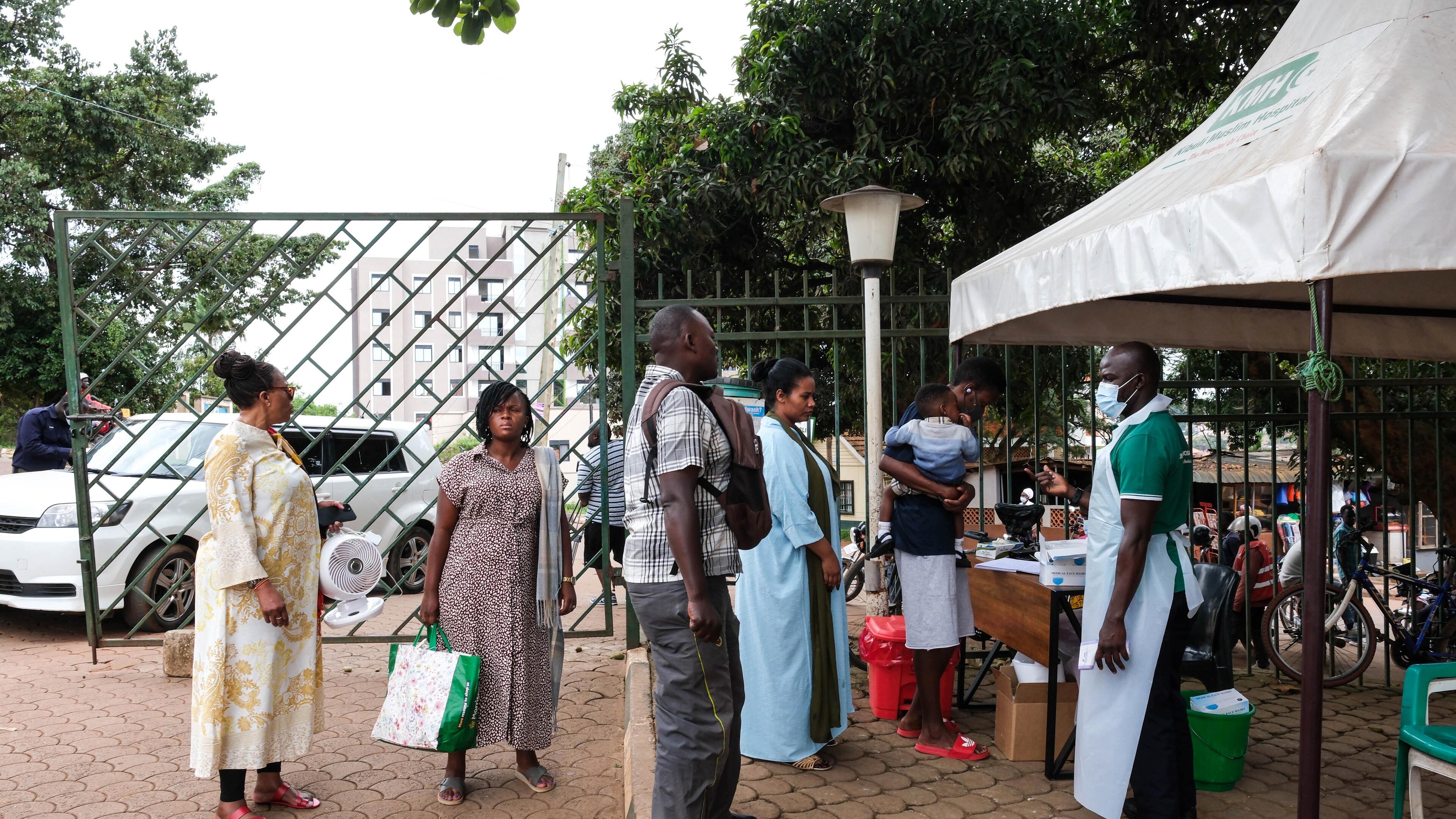 People wait to have their temperature taken in front of Kibuli Muslim Hospital in Kampala, Uganda, Saturday, May 16, 2026. (AP Photo/ Hajarah Nalwadda)