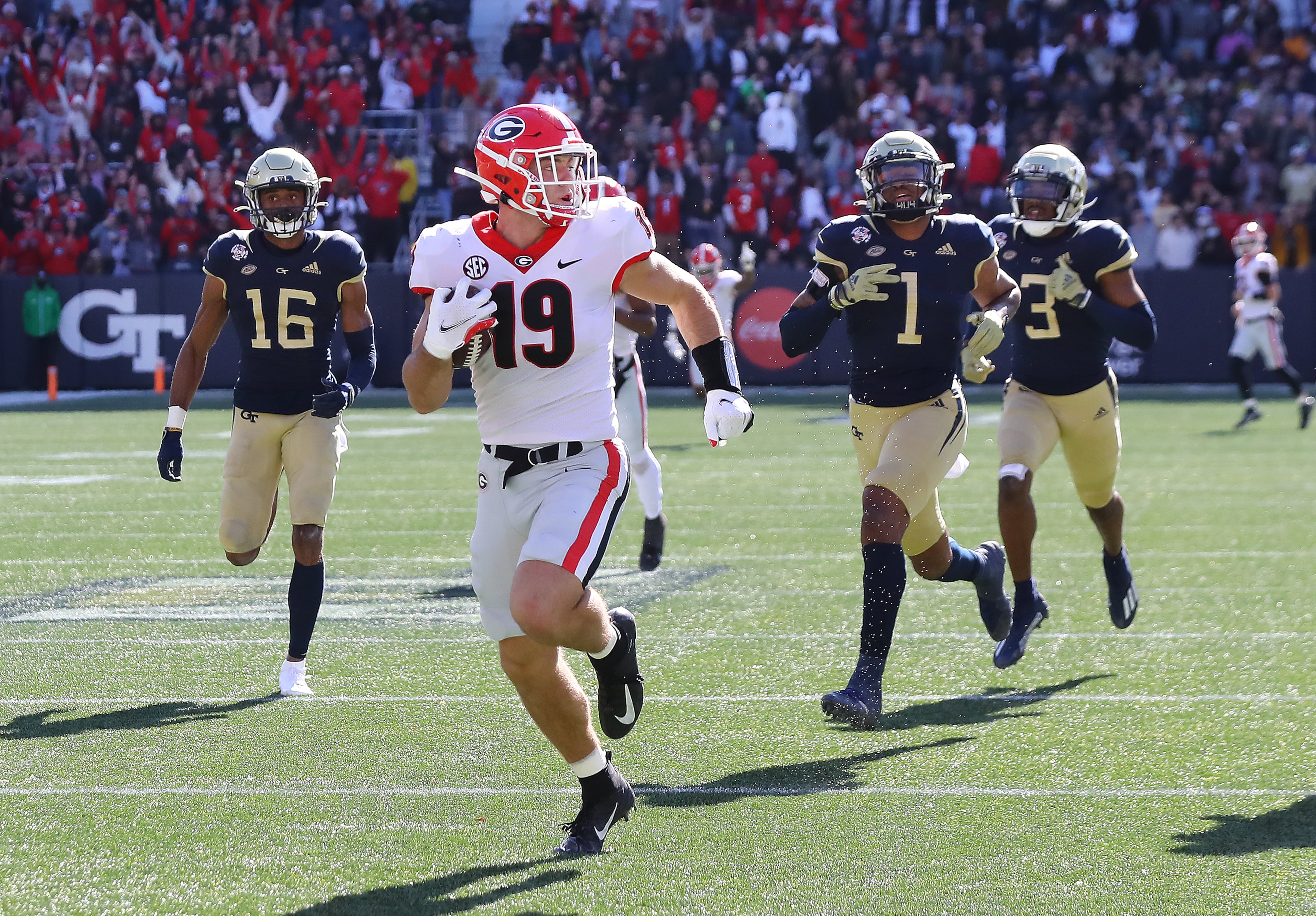 Georgia tight end Brock Bowers looks over his shoulder at Georgia Tech defenders as he heads to the end zone on a long touchdown reception to take a 24-0 lead over Georgia Tech during the second quarter in a NCAA college football game on Saturday, Nov. 27, 2021, in Atlanta. “Curtis Compton / Curtis.Compton@ajc.com”`
