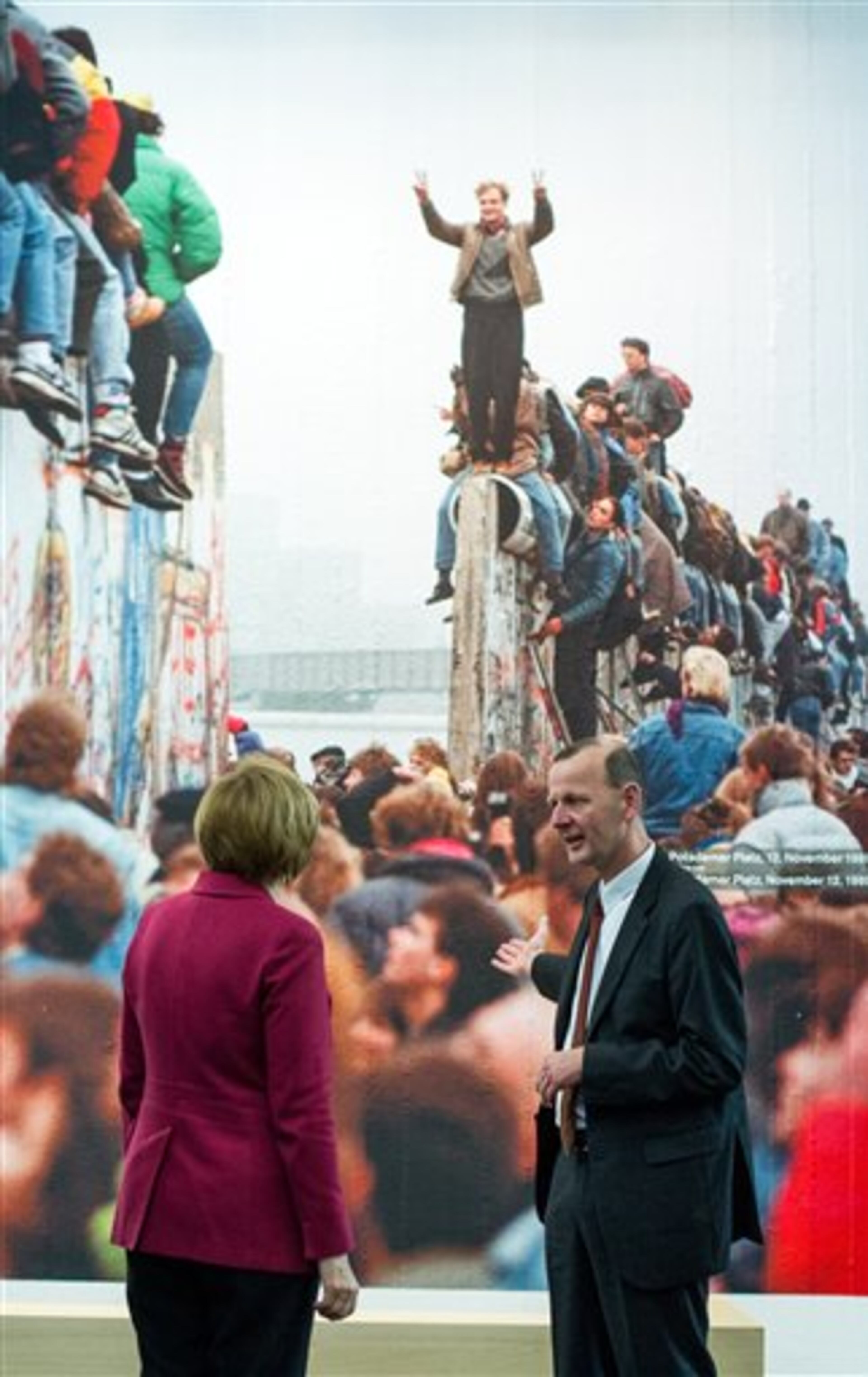 German Chancellor Angela Merkel and Director of the Berlin Wall Foundation Axel Klausmeier visit the new permanent exhibition in the Berlin Wall memorial at Bernauer Strasse in Berlin, Germany, Sunday, Nov. 9, 2014. 25 years ago - on Nov. 9, 1989 - the East-German government lifted travel restrictions and thousands of East Berliners had pushed their way past perplexed border guards to celebrate freedom with their brethren in the West. (AP Photo/dpa, Bernd von Jutrczenka)