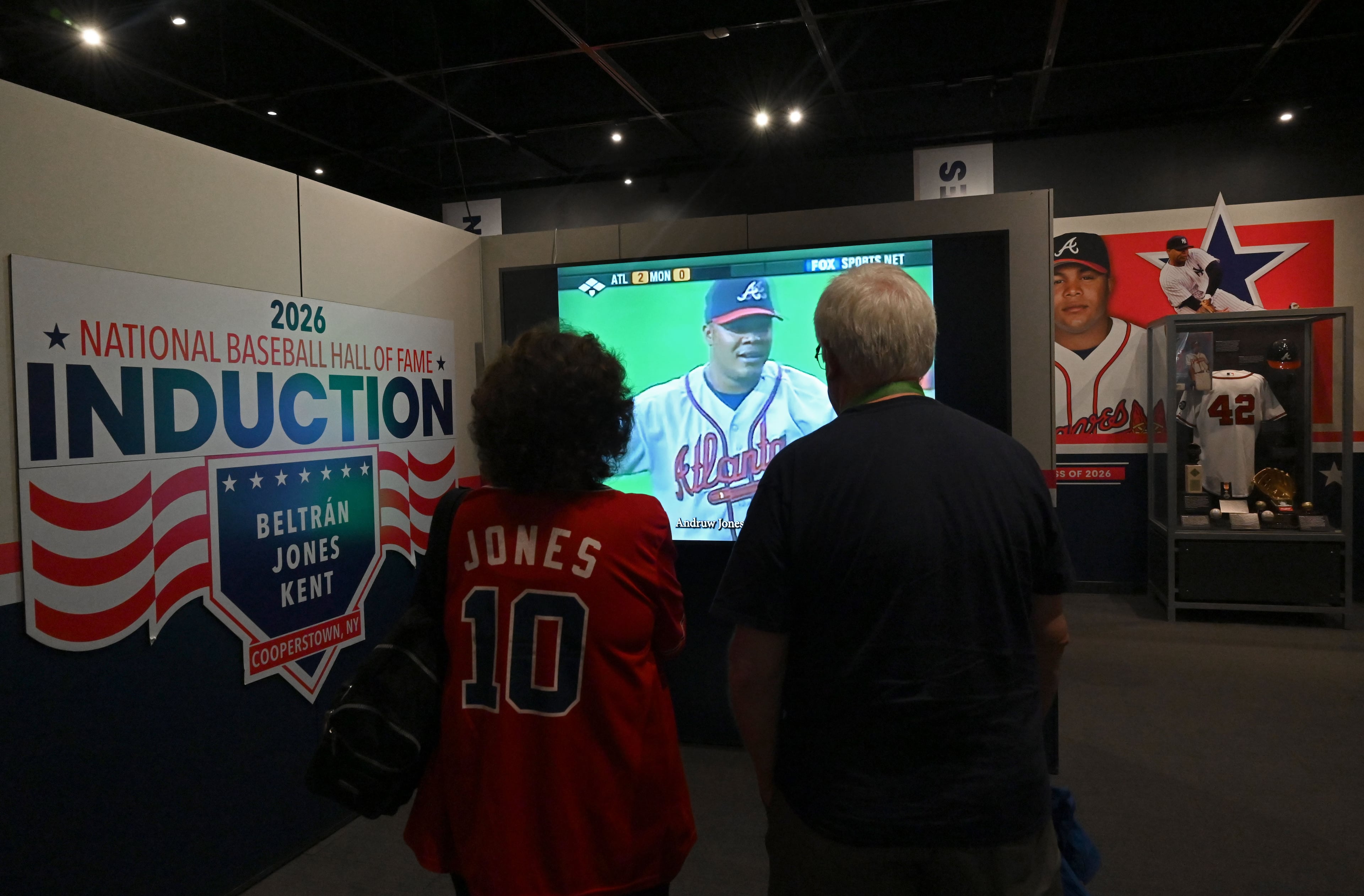 Atlanta Braves fans Cathy and Bill Spencer of Atlanta check out displays featuring former Atlanta Braves center fielder Andruw Jones at the National Baseball Hall of Fame and Museum on Friday, July 24, 2026, in Cooperstown, N.Y. Andruw Jones will be inducted into the National Baseball Hall of Fame on Sunday as part of the Class of 2026, alongside Carlos Beltrán and Jeff Kent. He is recognized as one of the greatest center fielders in baseball history. Jones will become the 12th player with ties to the Atlanta Braves to be inducted into the Hall of Fame. (Hyosub Shin/AJC)
