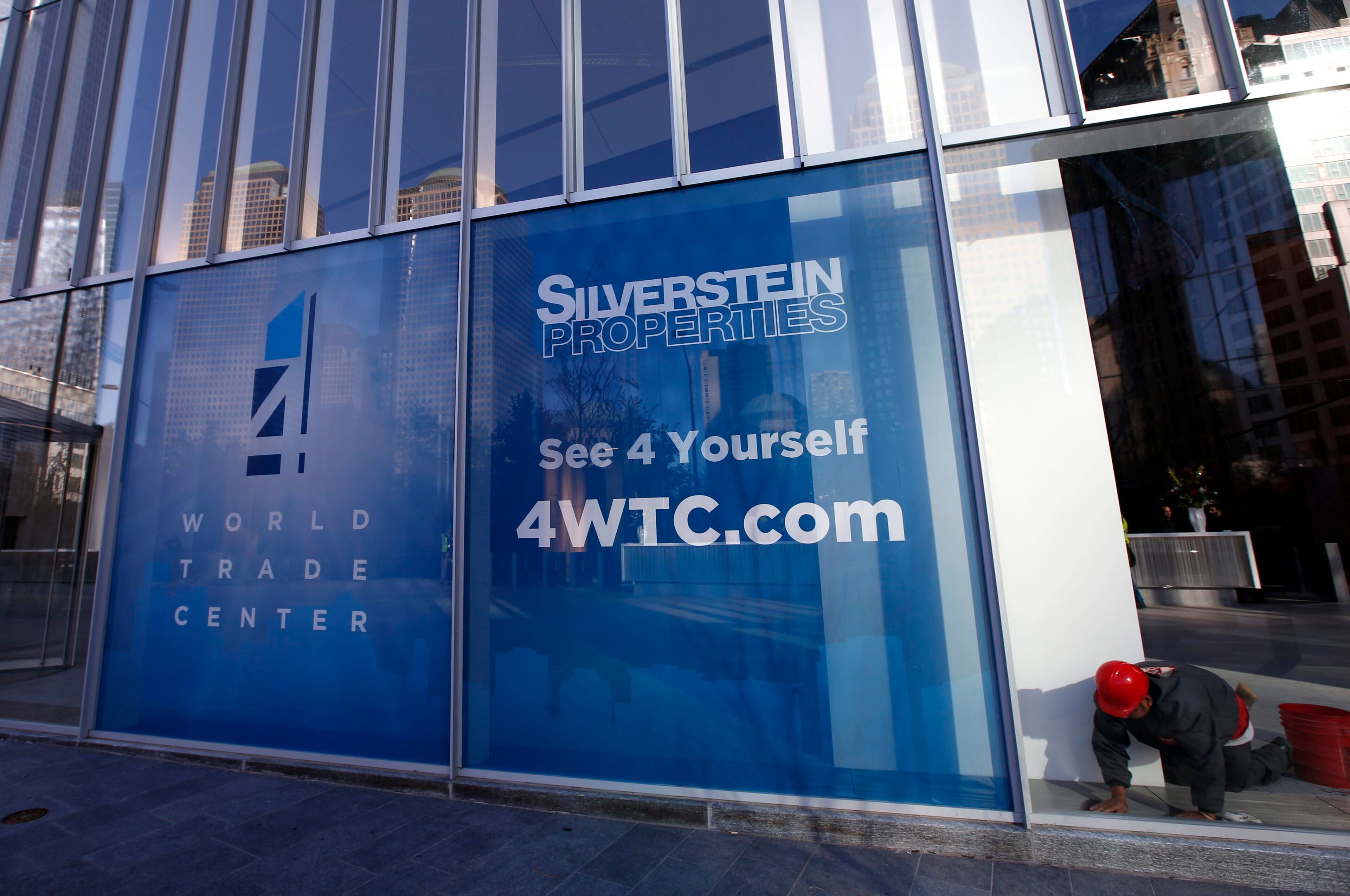 A worker puts finishing touches on a window in the lobby of the soon to be opened 4 World Trade Center tower in New York, November 8, 2013. 4 World Trade center sits at the south east corner of the World Trade Center site and will be the second tower to open on the site since the 2001 attacks on the World Trade Center. REUTERS/Mike Segar (UNITED STATES - Tags: CITYSCAPE BUSINESS)