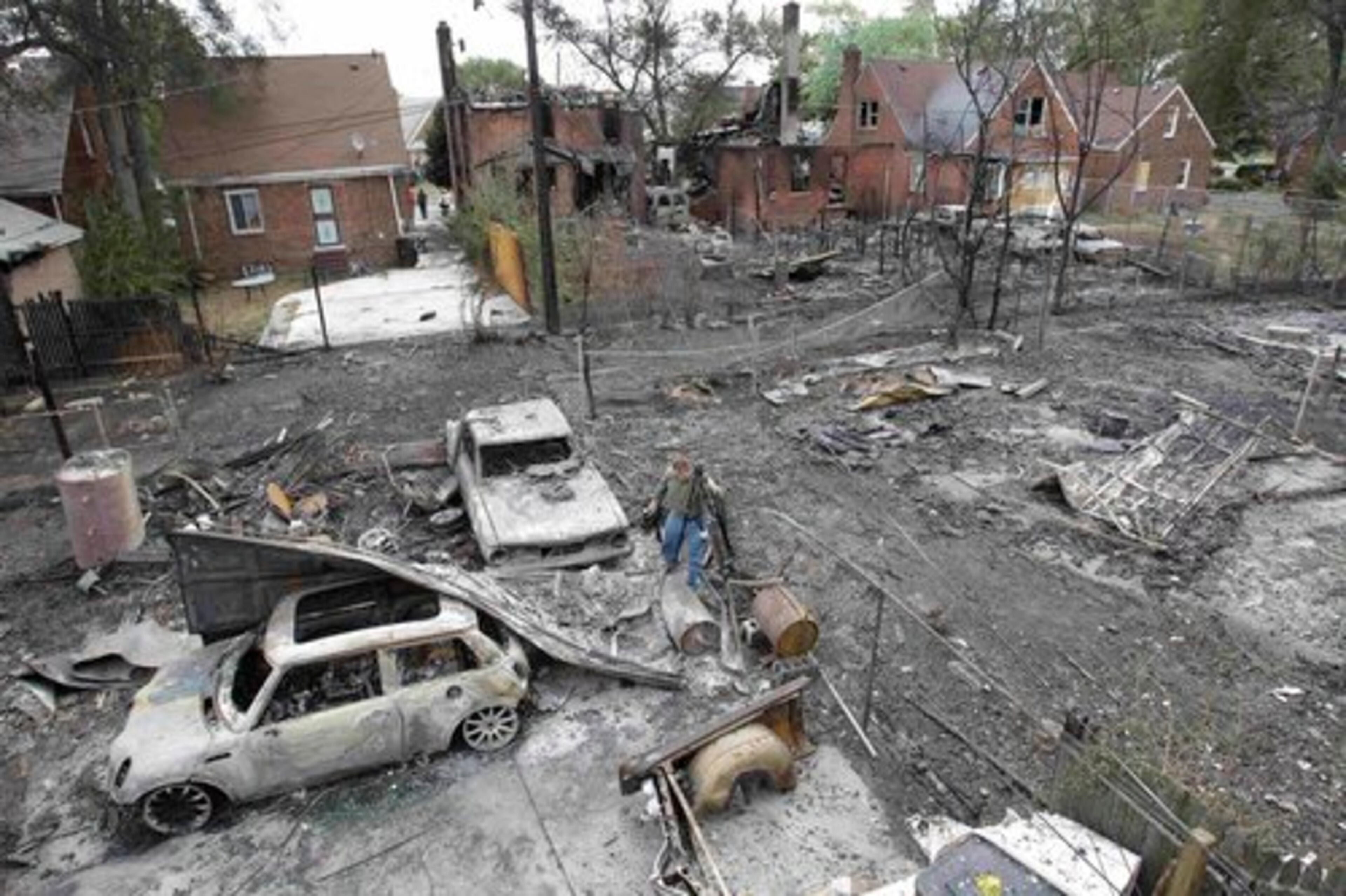 Burned cars and property are seen on the west side of Detroit, Wednesday, Sept. 8, 2010. Fire officials say flames have swept through at least two dozen homes in Detroit, fanned by strong winds that are toppling power lines across the city.