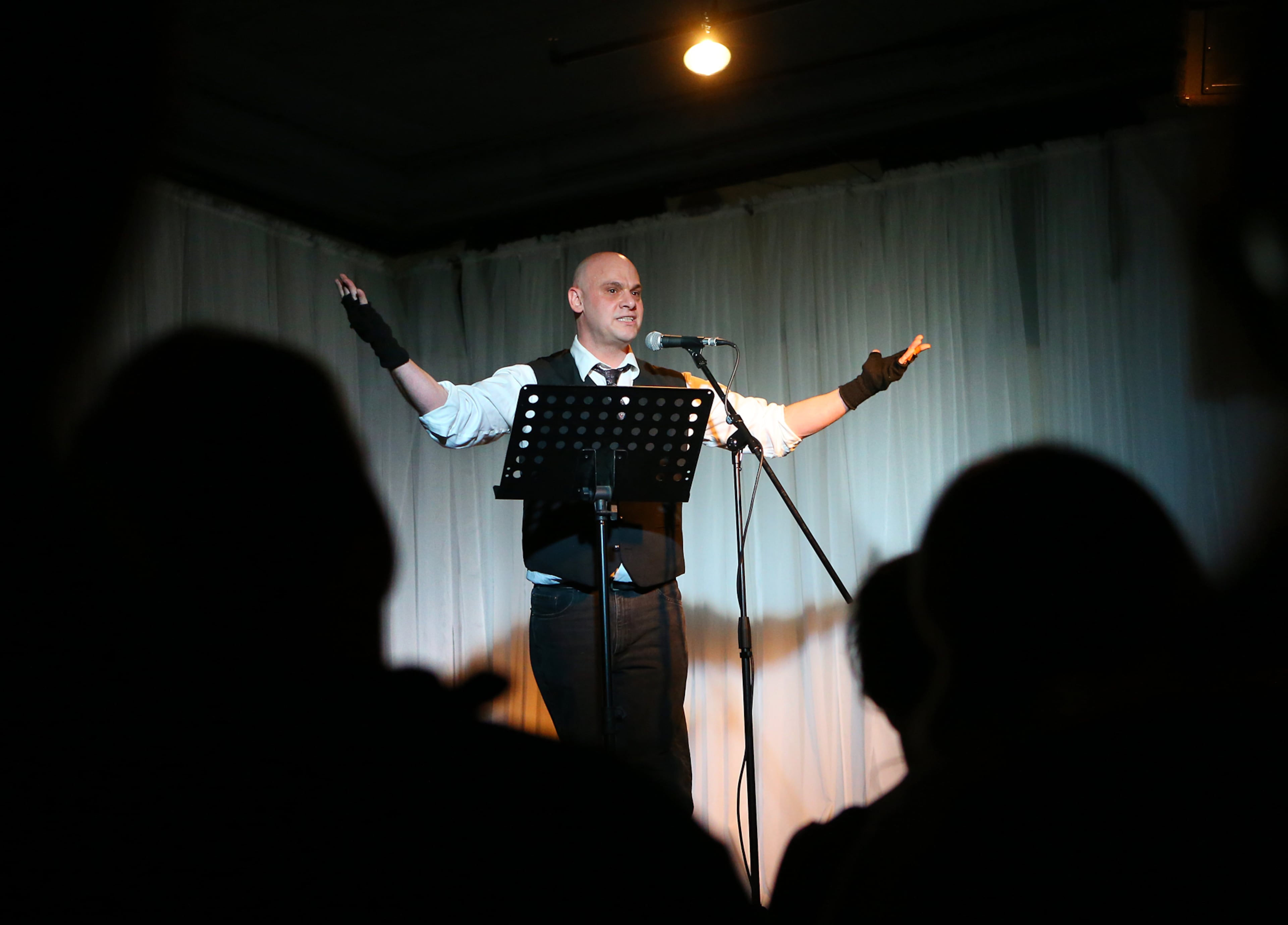 Rob Mosca concludes his story presentation to the audience during the monthly meeting of the Write Club at the Highland Ballroom on Monday, Feb 9, 2015, in Atlanta. The pugnacious group of authors choose sides on an abstract topic and go toe to toe to see who writes it better. The audience of tipplers and hecklers decides who wins. Curtis Compton / ccompton@ajc.com