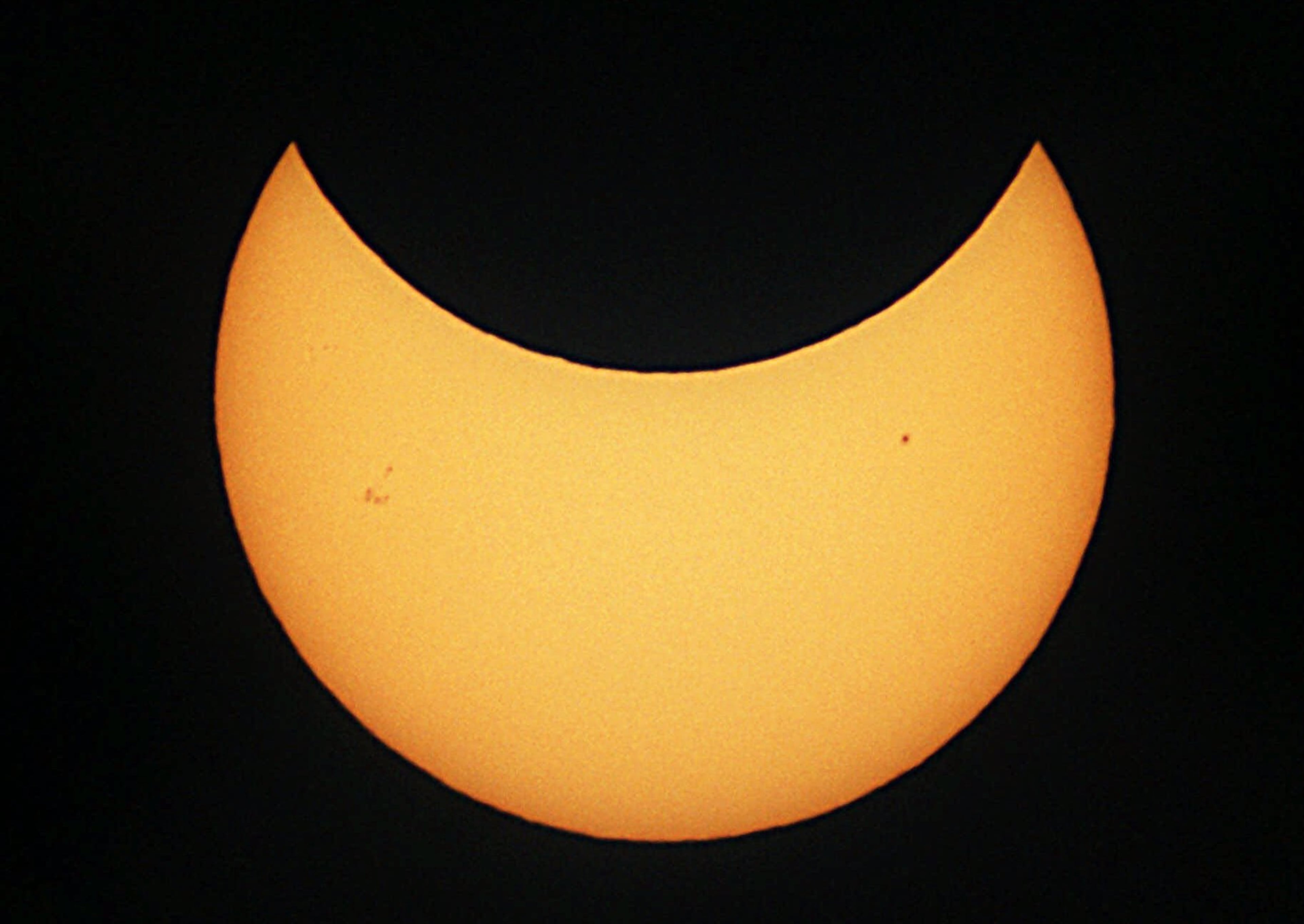 The moon obscures the edge of the sun during a Christmas Day partial solar eclipse Monday, Dec. 25, 2000 in Stedman, N.C. This photo was made with an amateur astronomer's telescope equipped with a solar filter. Several sunspots are visible on the unobscured portion of the sun. A Christmas Day solar eclipse won't be repeated for more than 300 years. (AP Photo/The Fayetteville Observer, Johnny Horne)