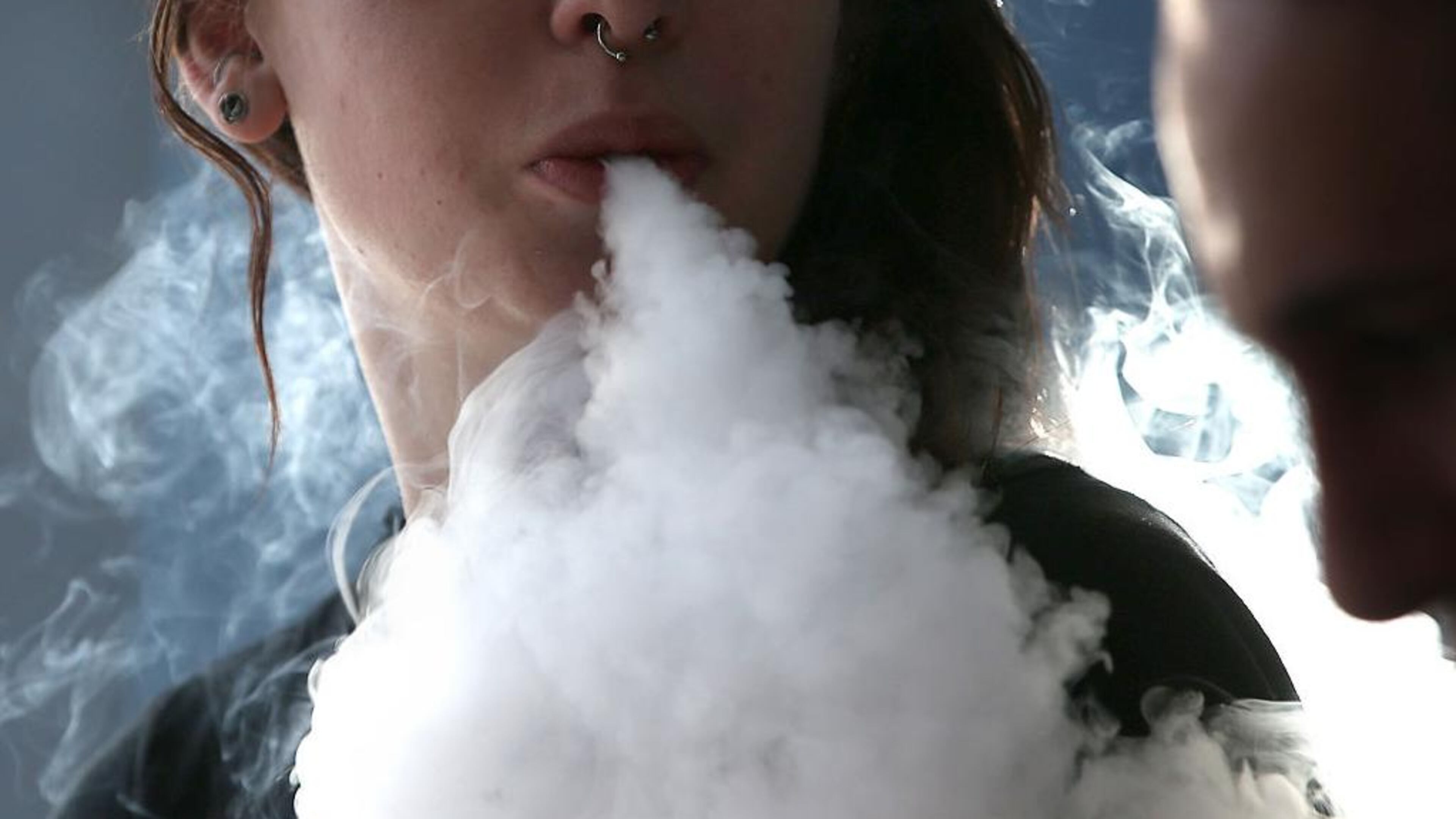 A girl smokes an e-cigarette. A new study recorded a dramatic uptick in the numbers of teenagers vaping nicotine in the past year. Experts are worried about the health affects.