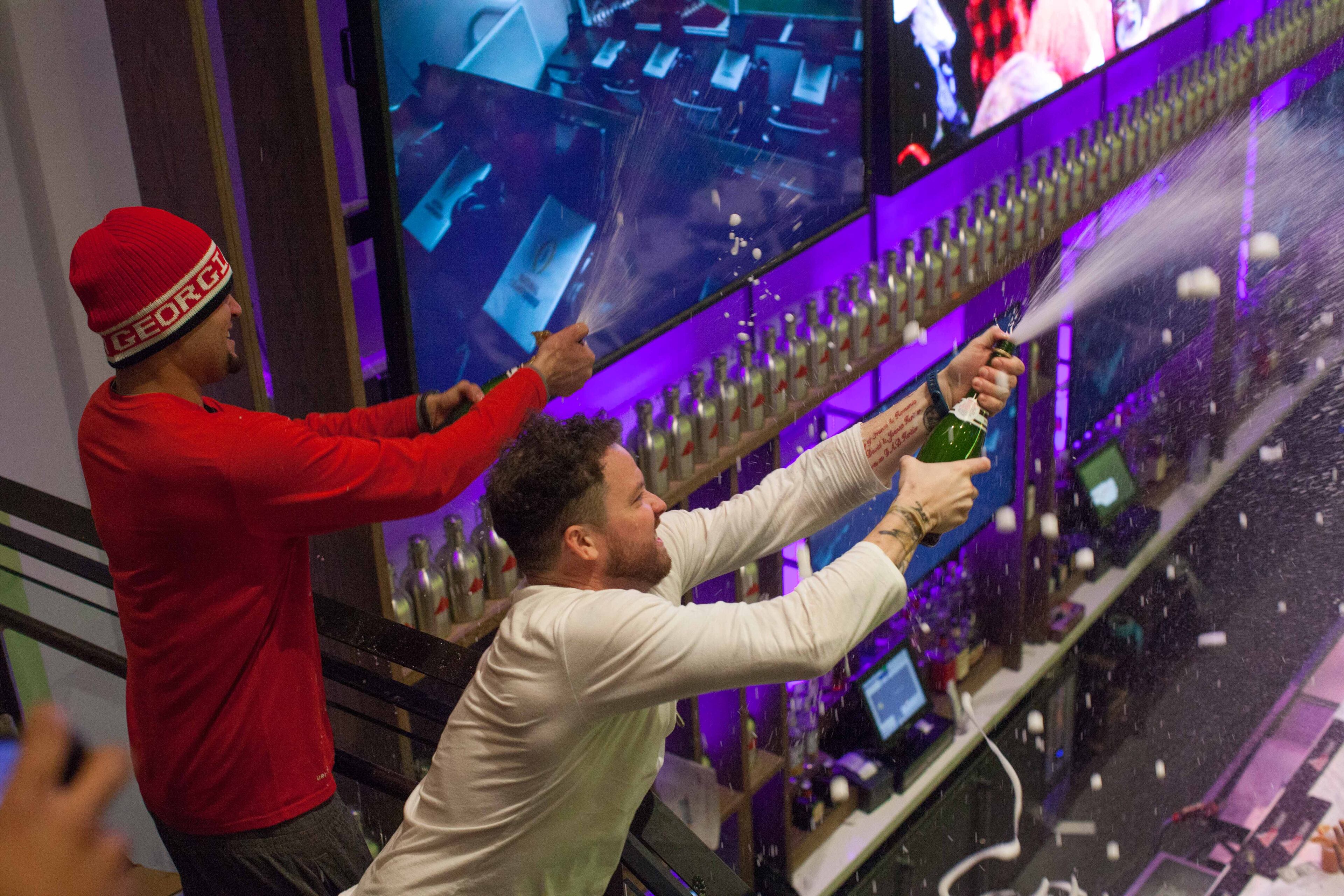 Sports & Social employees spray champagne on fans during the Rose Bowl NCAA college football game between Georgia and Oklahoma, Monday, Jan. 1, 2018, in Atlanta. BRANDEN CAMP/SPECIAL