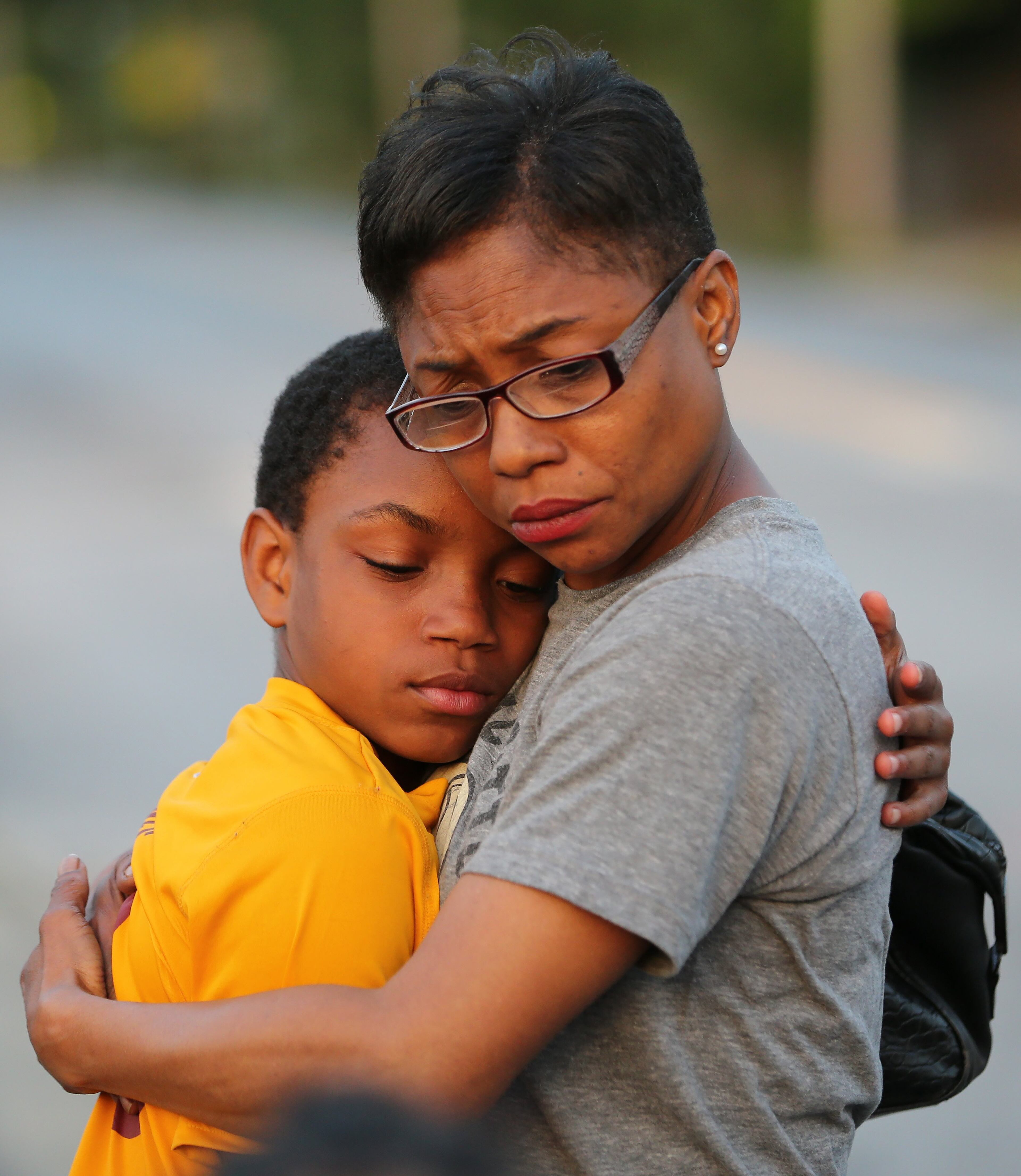 Helena McClain hugs her son Arthur Ballard, 11, while at a vigil for Ballard's friend Isaiah Ward on Wednesday evening April 20, 2016. Ward was hit and killed while walking on the sidewalk with his brother and a friend last Friday evening. Ben Gray / bgray@ajc.com