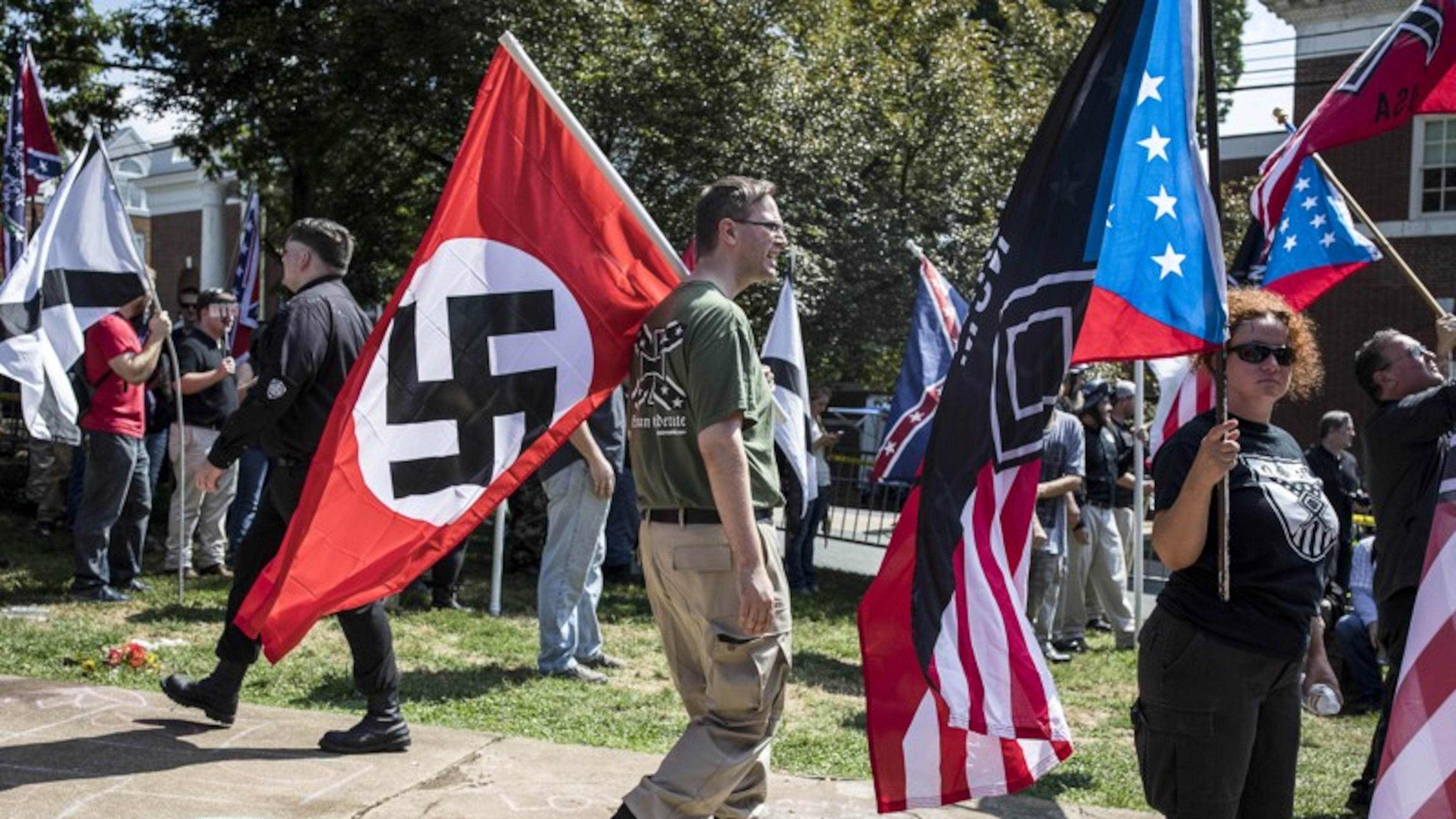 A white nationalist carries a Nazi flag during a protest in Charlottesville, Va., Aug. 12, 2017. (AJC File)