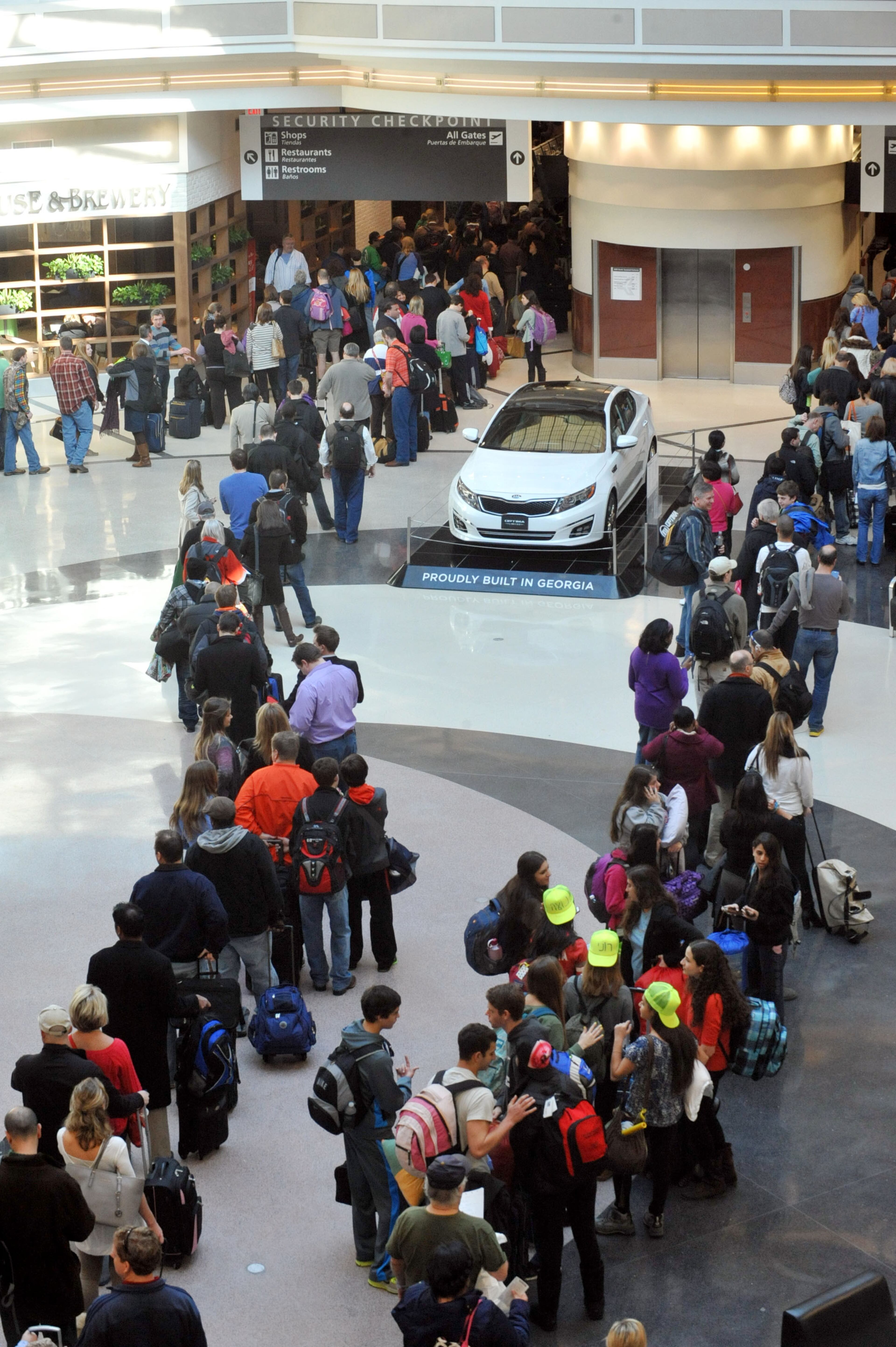 Travelers wait to go through the main security checkpoint at Hartsfield-Jackson International Airport Thursday. A TSA spokesman said many of its workers reported having trouble getting to the airport or could not immediately return to work due to issues such as child care while schools were still out.
