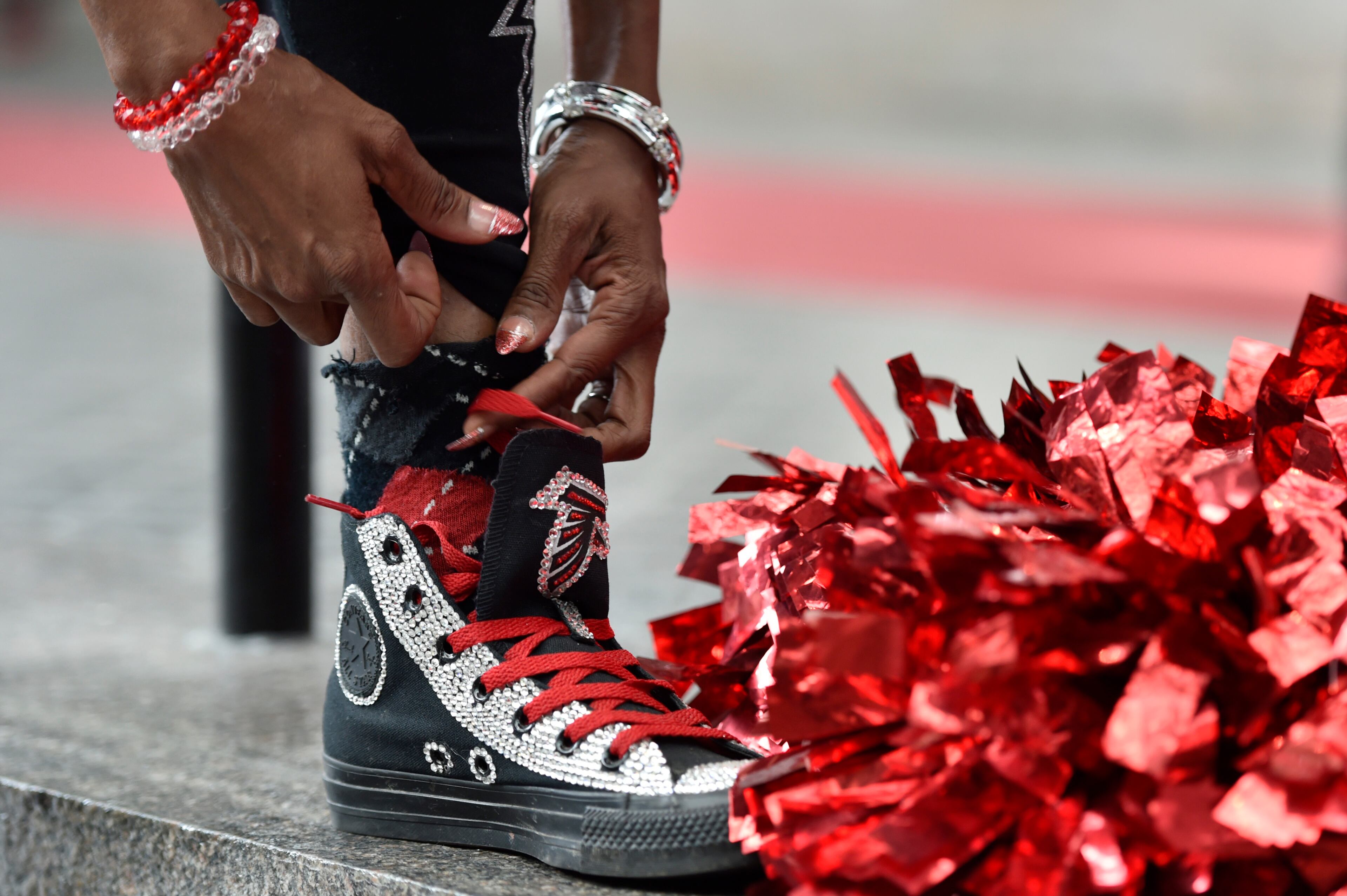 January 20, 2017, Atlanta - Keisha Burns, the "official bird lady", ties her Falcons themed shoes during a pep rally for the upcoming NFC Championship game against the Packers in Atlanta, Georgia, on Friday, January 20, 2017. (DAVID BARNES / DAVID.BARNES@AJC.COM)