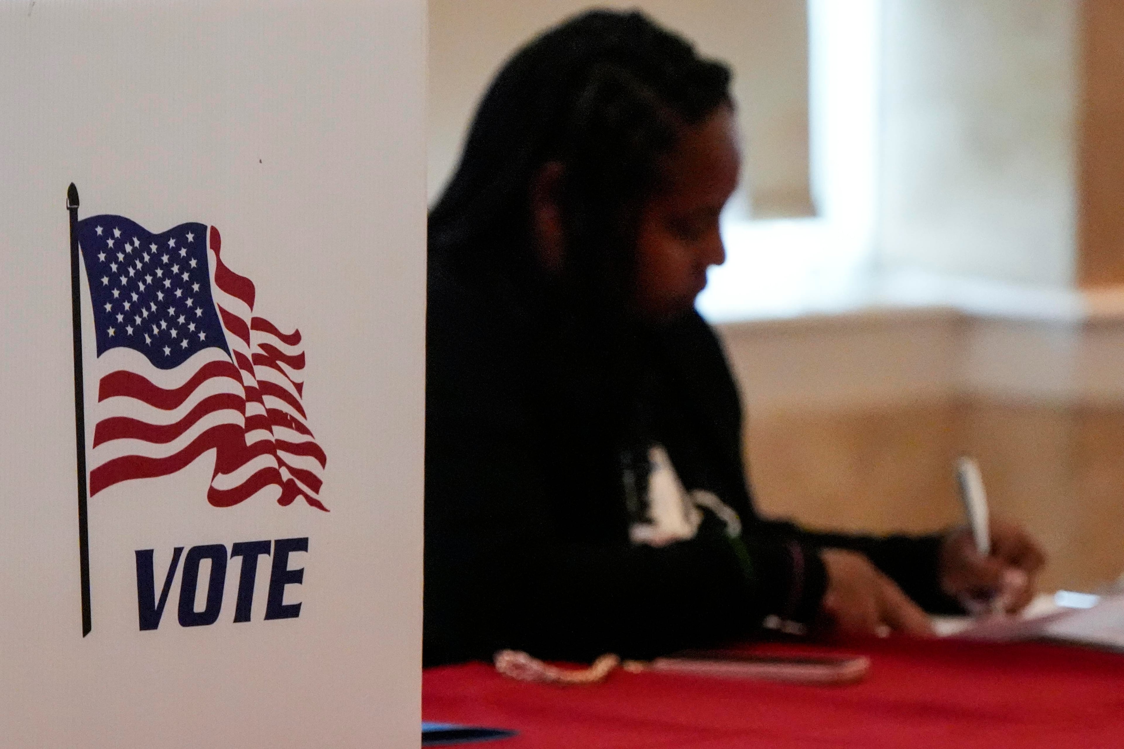 A Fulton County staff member works as people vote in a runoff election, Tuesday, June 16, 2026, in Atlanta. (AP Photo/Mike Stewart)