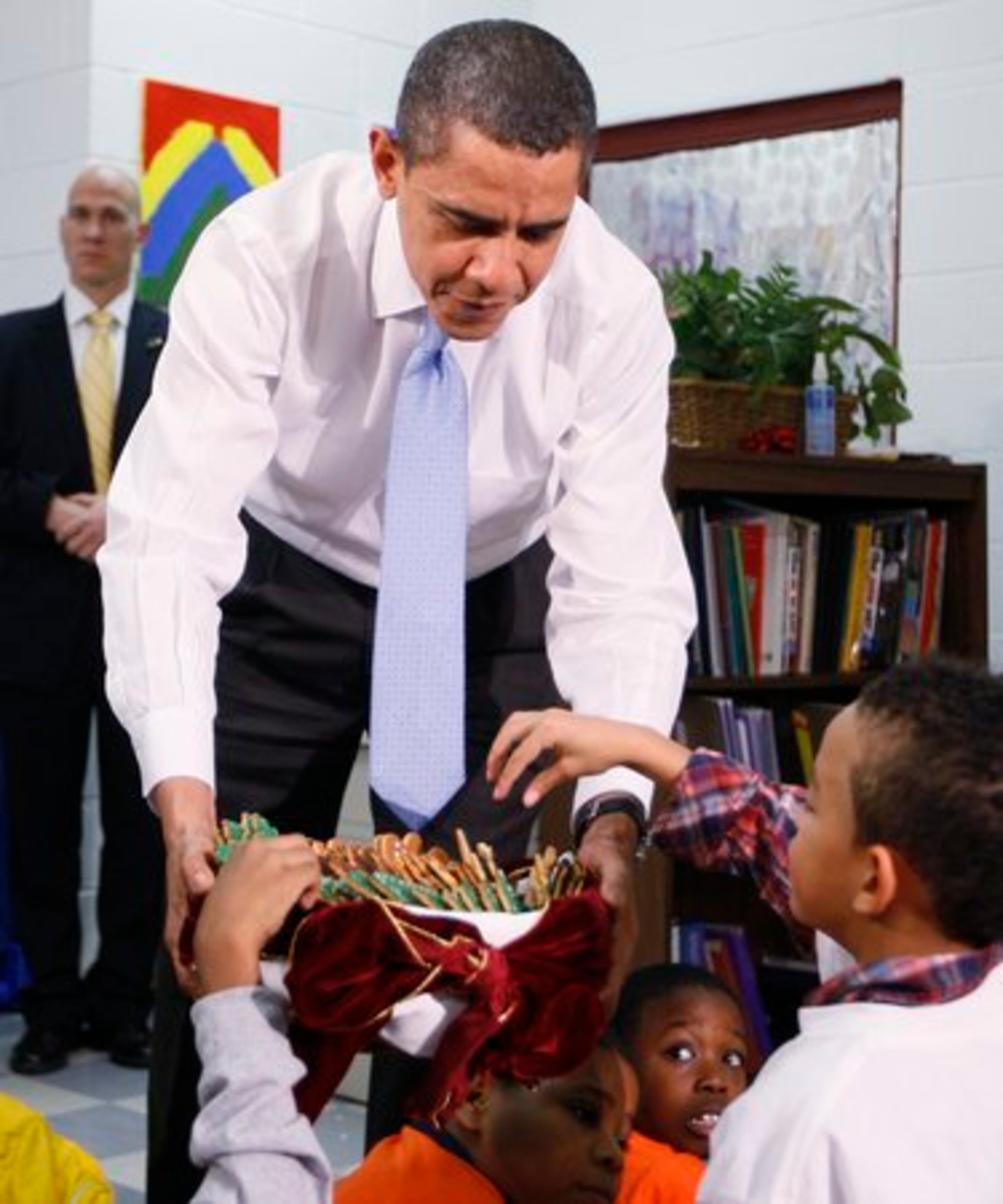 After he finished reading the story, the president rewarded the kids by offering them cookies from a red velvet-wrapped basket.
