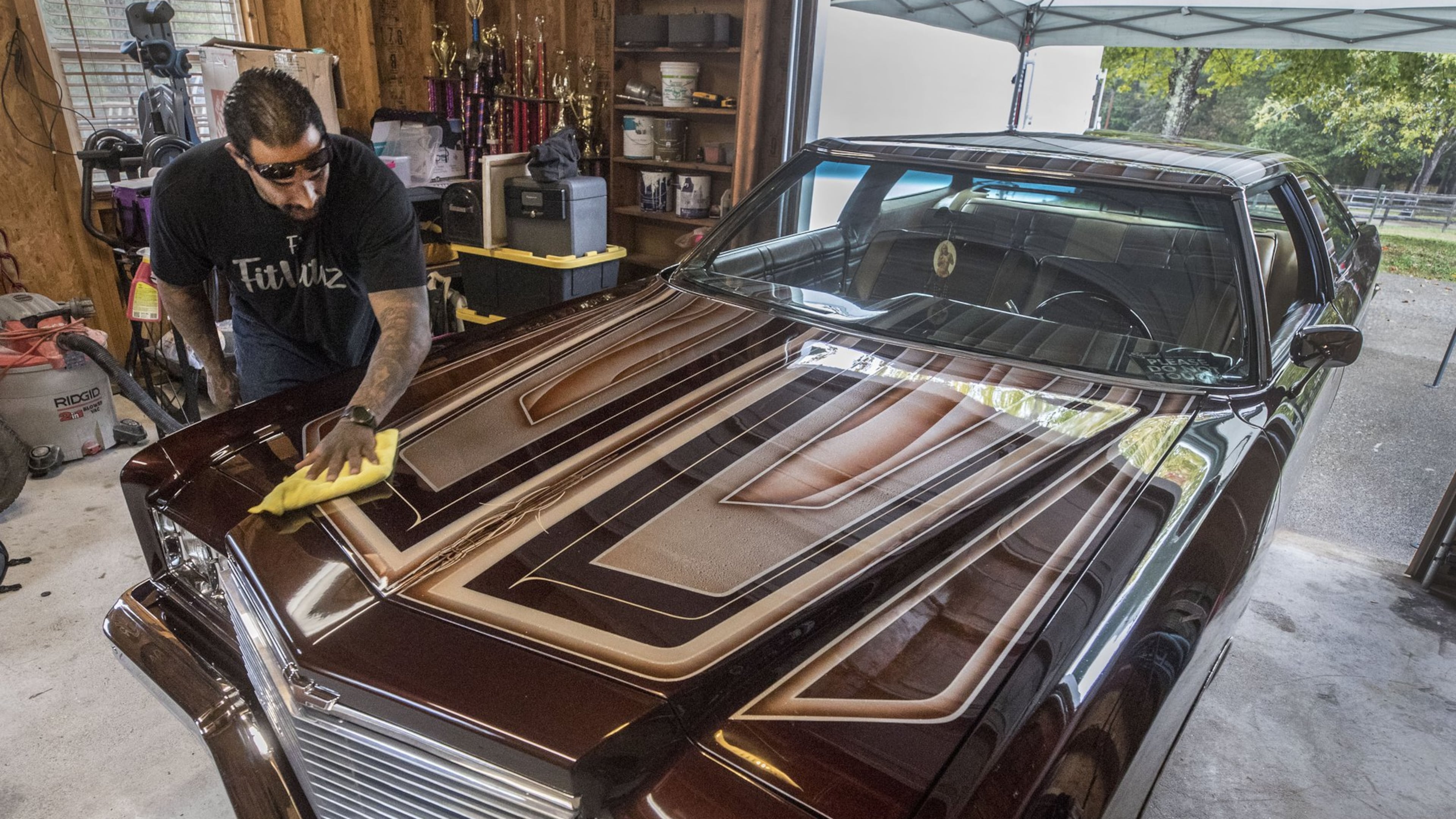 Alfredo “Freddy” Quintero gives his Impala a wipe down as he waits for the Hot Wheels trailer to pick up his car for the event. Quintero and his custom 1975 Chevy Impala are headed to the Hot Wheels Tour Grand Finale in Vegas, where the winner will be inducted into the Hot Wheels Garage of Legends. Bob Andres/robert.andres@ajc.com