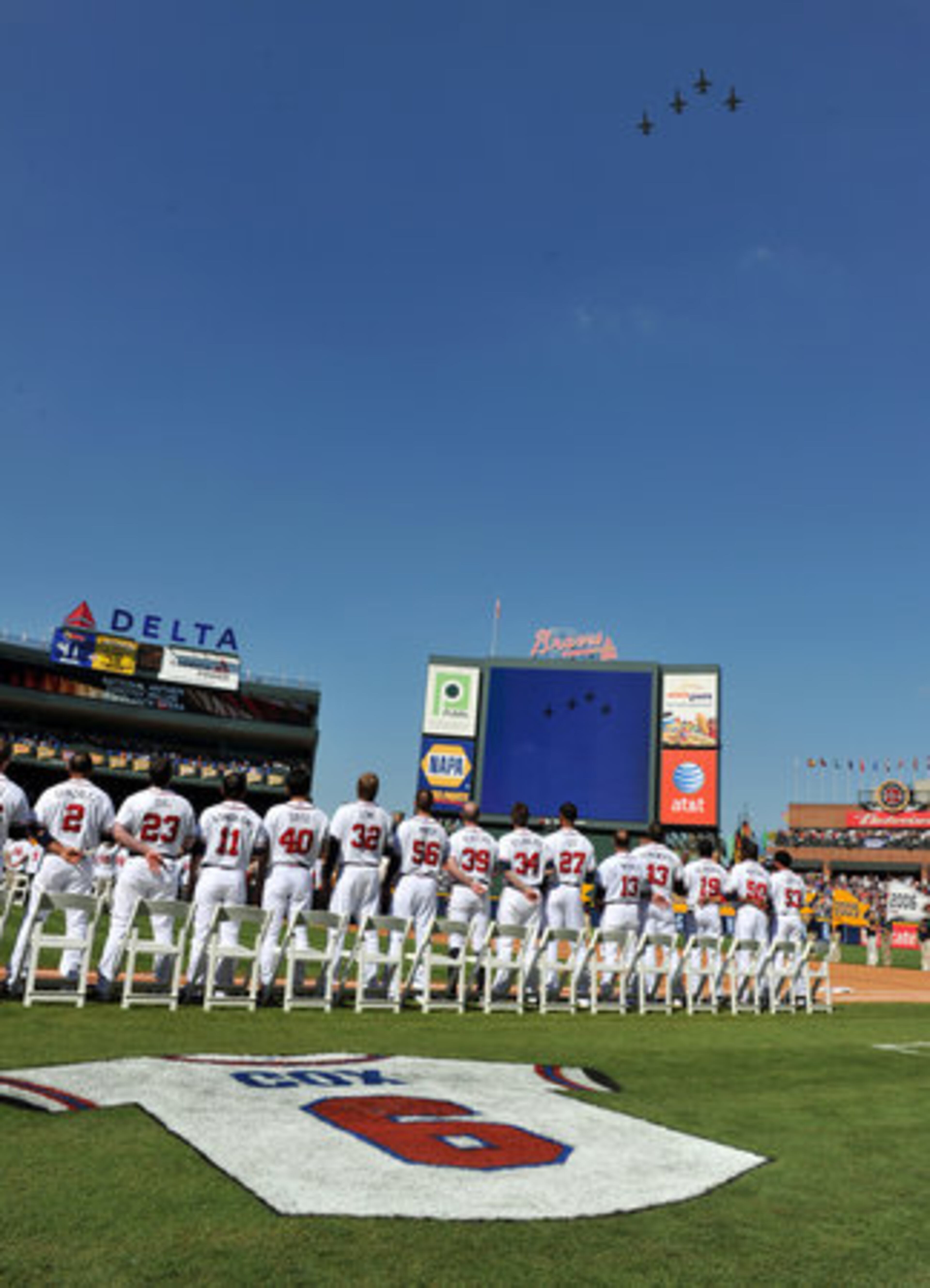 Braves players stand at attention as a military planes fly over during national anthem. The Braves were hosting Philadelphia Phillies.
