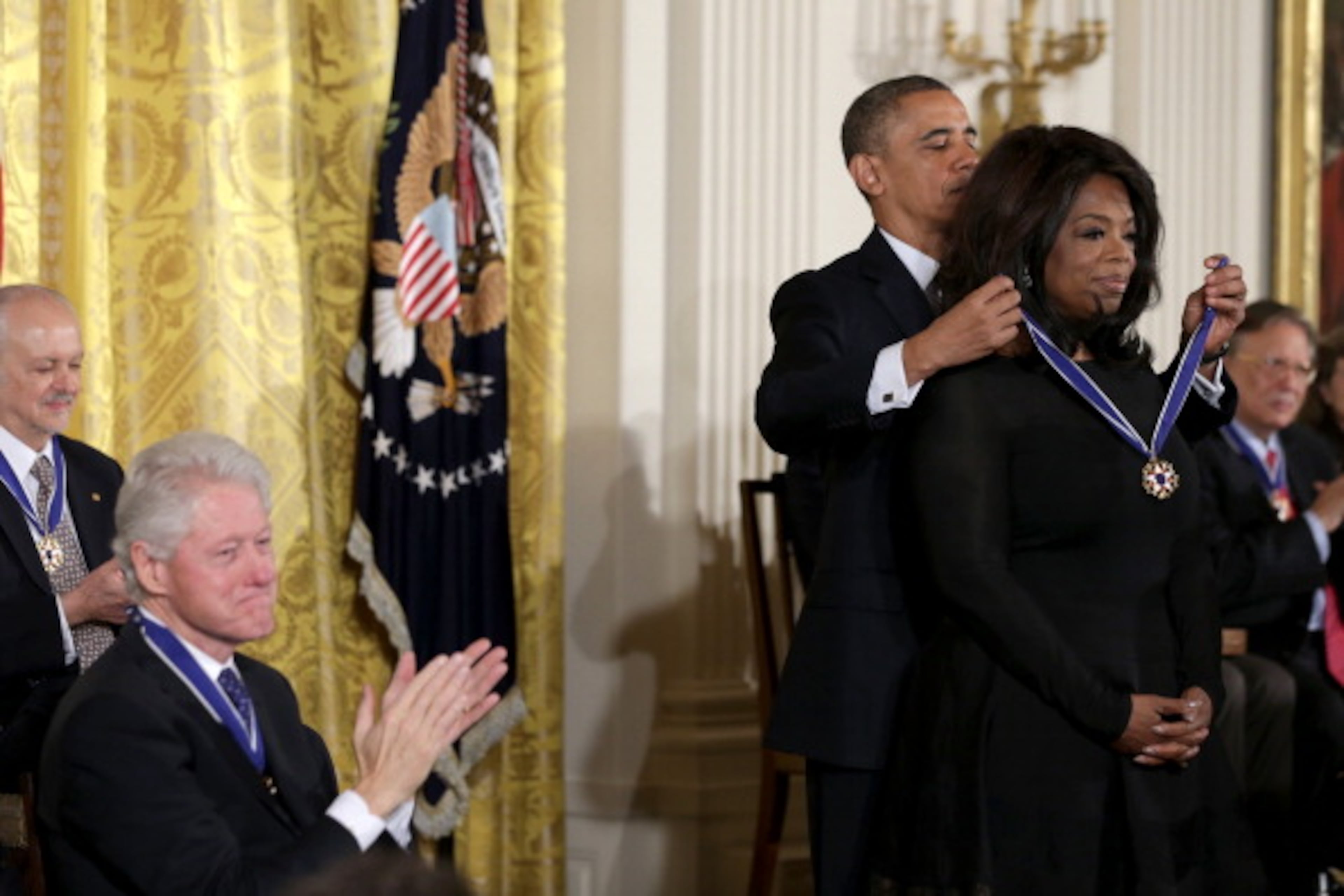 WASHINGTON, DC - NOVEMBER 20: U.S. President Barack Obama awards the Presidential Medal of Freedom to Oprah Winfrey as former U.S. President Bill Clinton claps in the East Room at the White House on November 20, 2013 in Washington, DC. The Presidential Medal of Freedom is the nation's highest civilian honor, presented to individuals who have made meritorious contributions to the security or national interests of the United States, to world peace, or to cultural or other significant public or private endeavors. (Photo by Alex Wong/Getty Images)