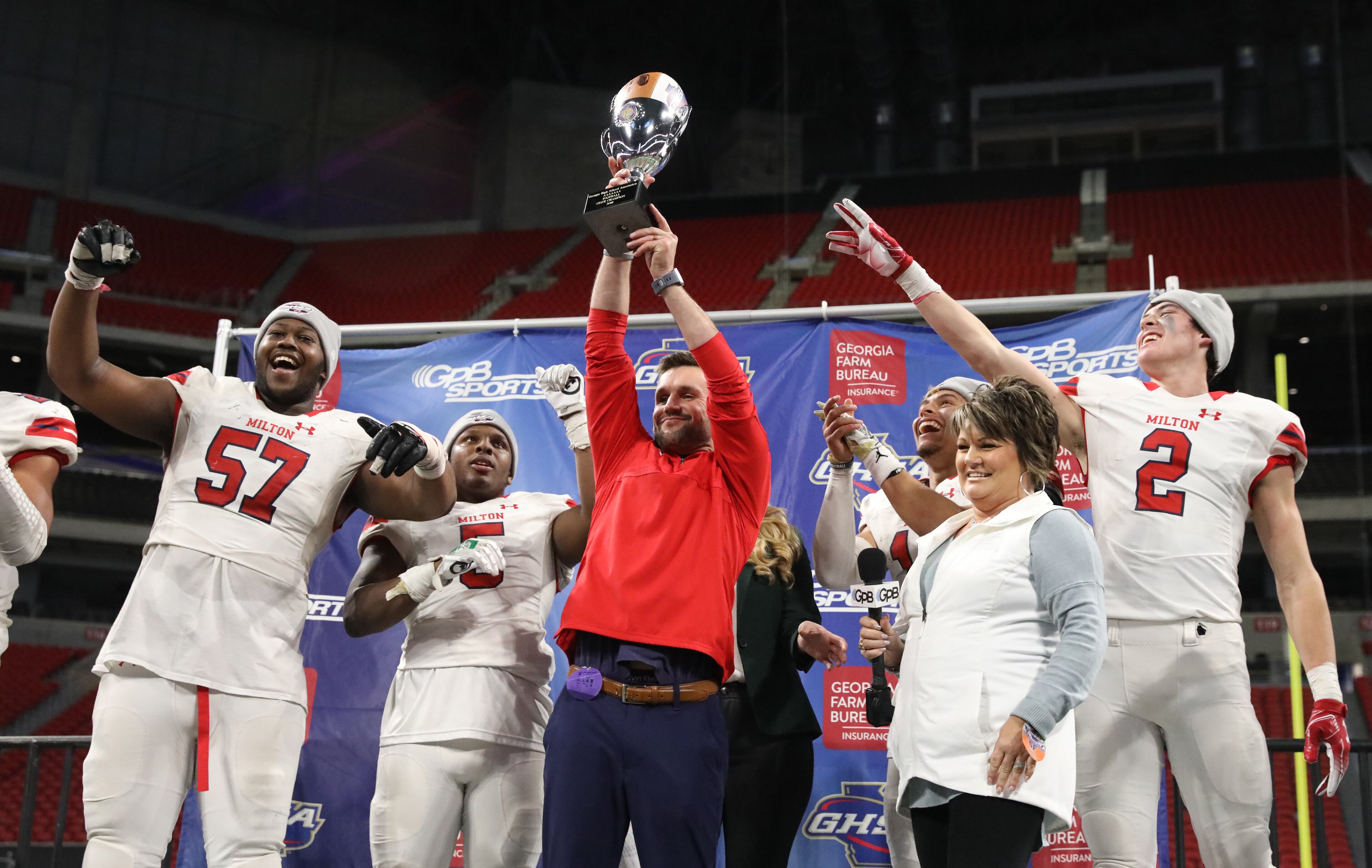 December 12, 2018 - Atlanta, Ga: Milton coach Adam Clack celebrates with the trophy with players from left; Paul Tchio (57), Jordan Davis, Jordan Yates, and Dylan Leonard after their 14-13 win against Colquitt County in the Class AAAAAAA State Championship at Mercedes-Benz Stadium Wednesday, December 12, 2018, in Atlanta. Milton won 14-13. (JASON GETZ/SPECIAL TO THE AJC)