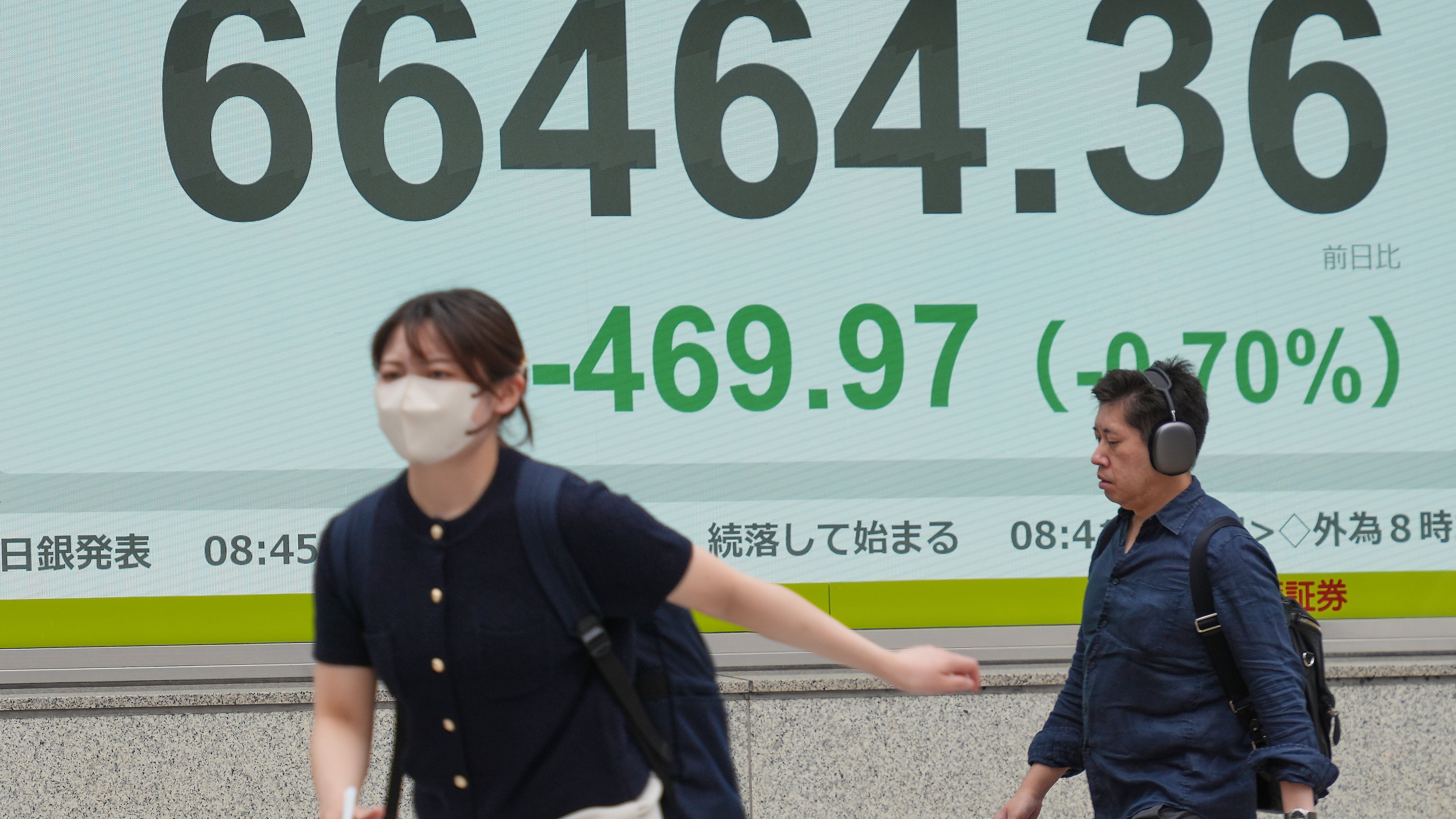 People walk in front of an electronic stock board showing Japan's Nikkei index at a securities firm Tuesday, June 2, 2026, in Tokyo. (AP Photo/Eugene Hoshiko)