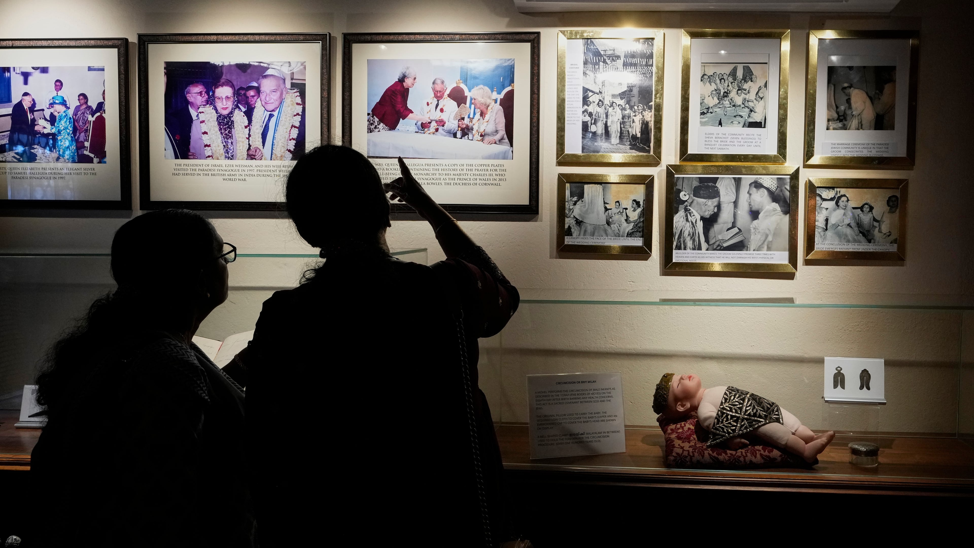 Visitors view photos displayed inside a museum showcasing Cochin's Jewish history next to the 458-year-old Paradesi Synagogue in the historic Jew Town neighborhood of Kochi, India, Wednesday, May 20, 2026. (AP Photo/Aijaz Rahi)