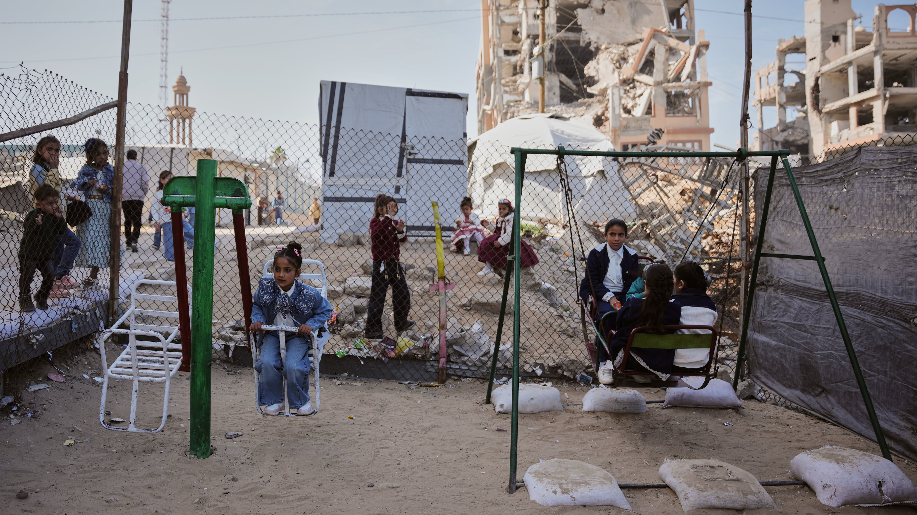 FILE - Displaced Palestinian children play on a swing at a tent camp as they mark the Muslim holiday of Eid al-Fitr in Gaza City, Friday, March 20, 2026. (AP Photo/Abdel Kareem Hana, file)