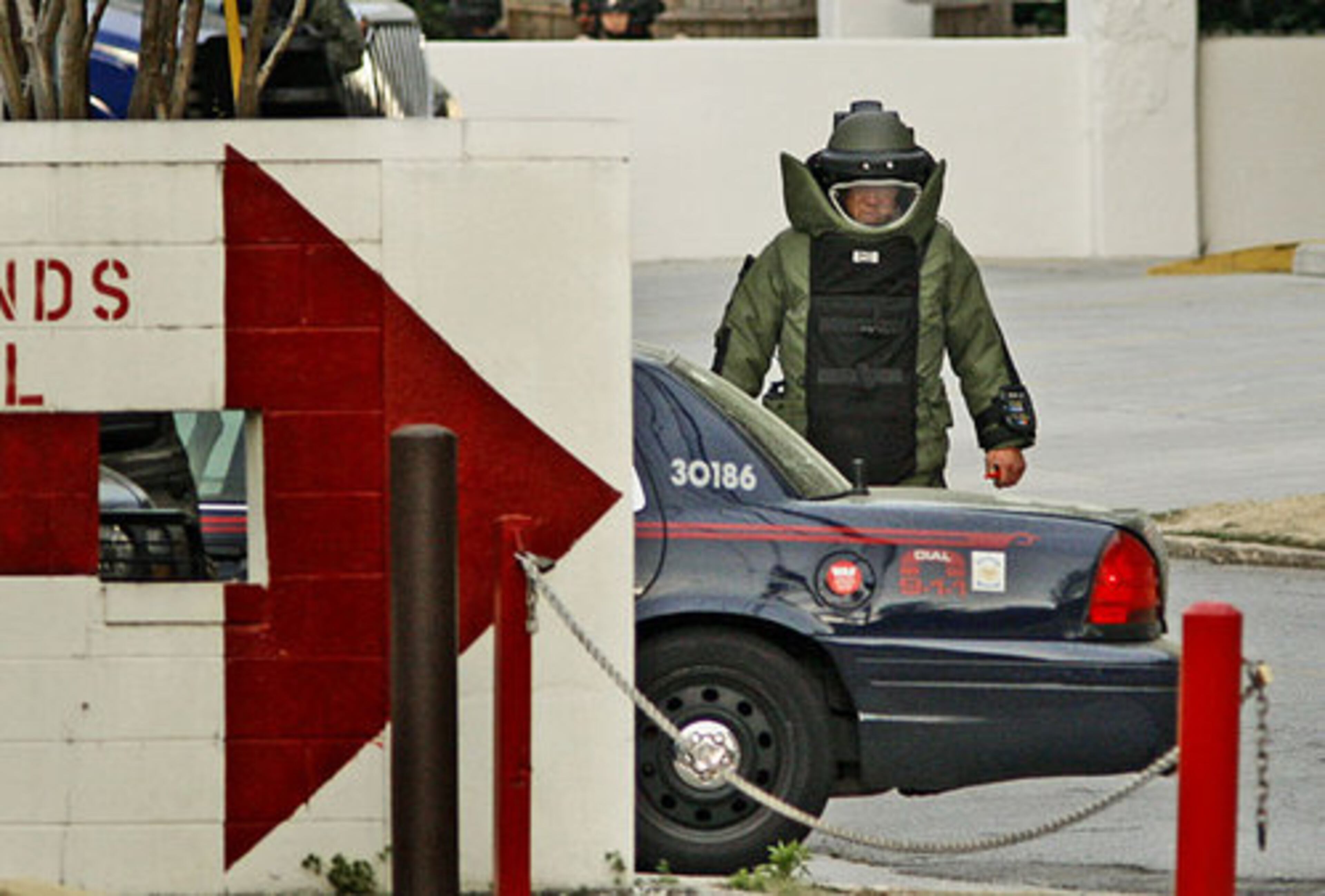 APD Bomb unit officer approaches suspects vehicle behind the wall Thursday.