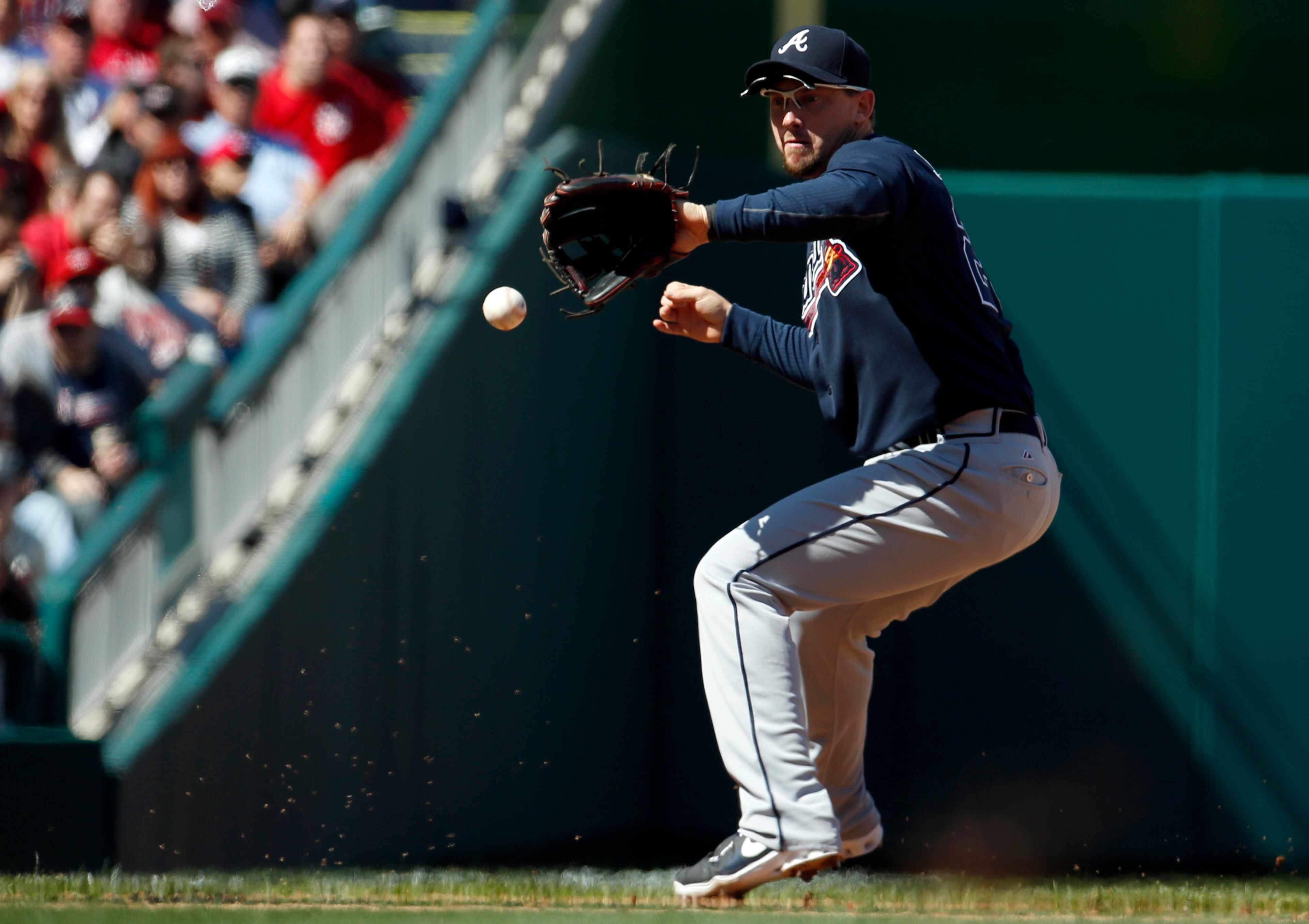 Atlanta Braves third baseman Chris Johnson fields a ball hit by Washington Nationals' Sandy Leon, who was out at first on the the play, during the fifth inning of a baseball game at Nationals Park, Sunday, April 6, 2014, in Washington. (AP Photo/Alex Brandon)