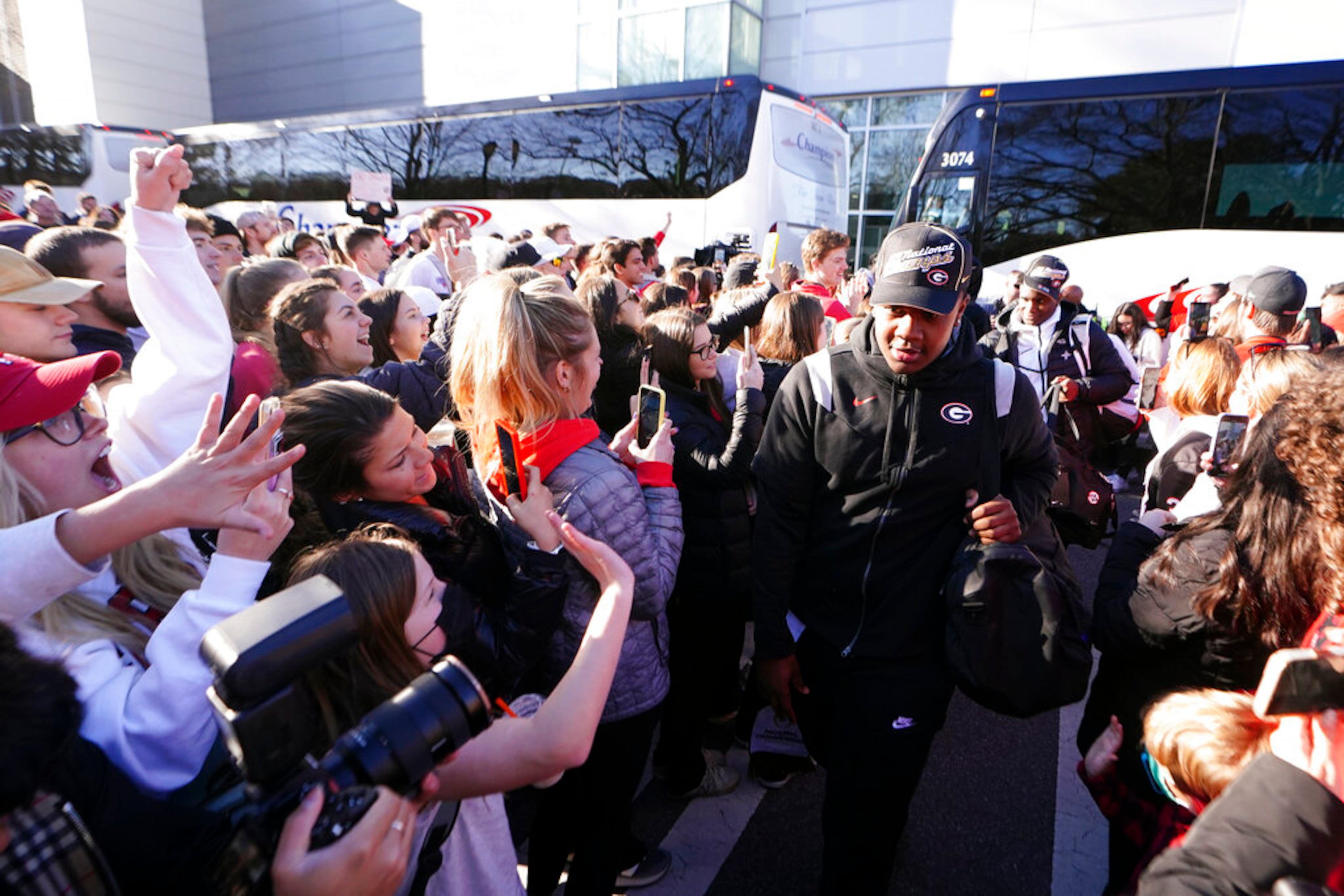 Georgia players are greeted by a large crowd of fans as they return to the Georgia campus, Tuesday, Jan. 11, 2022, in Athens, Ga., after defeating Alabama in the College Football Championship NCAA college football game. (AP Photo/John Bazemore)
