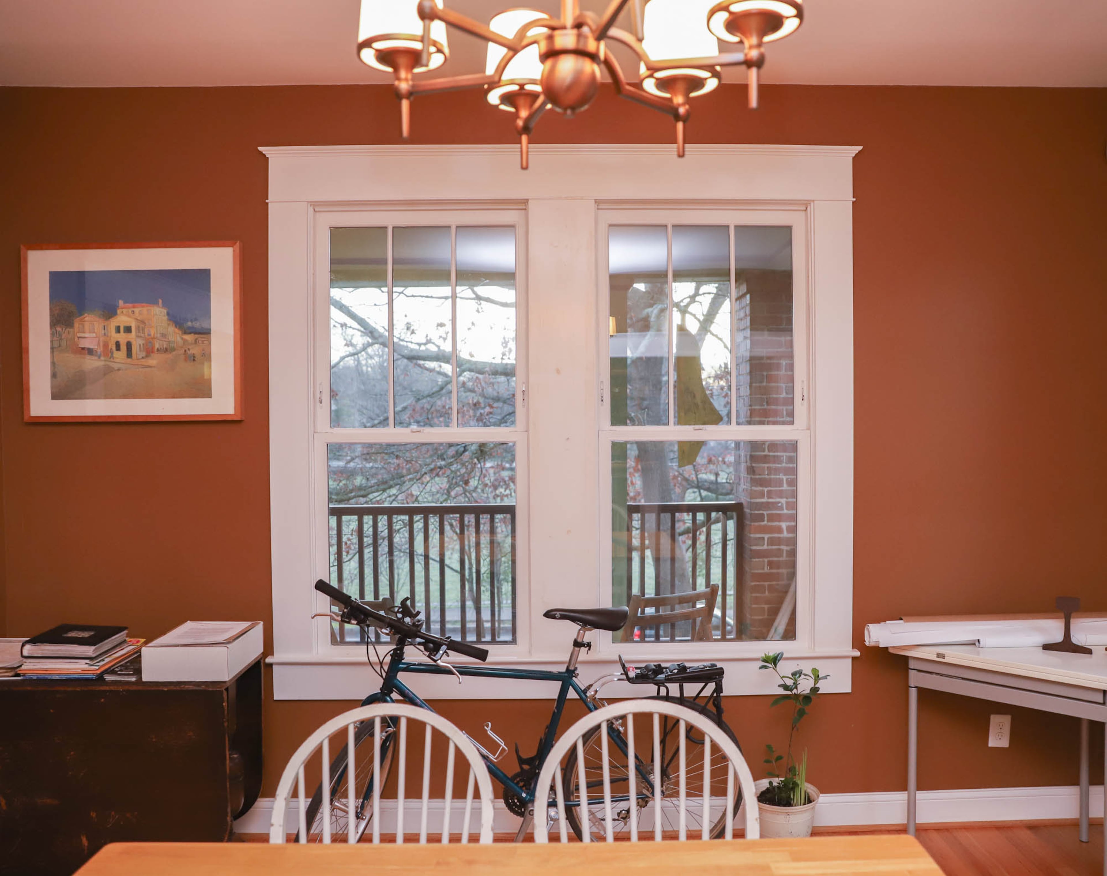 The three-over-one windows fit the original style of the 1910 home, said homeowner Angel Poventud. Friends gave him the table and chairs for the dining room, which overlooks a neighborhood park. The walls are painted Antiquarian Brown from the Sherwin-Williams Historic Collection.