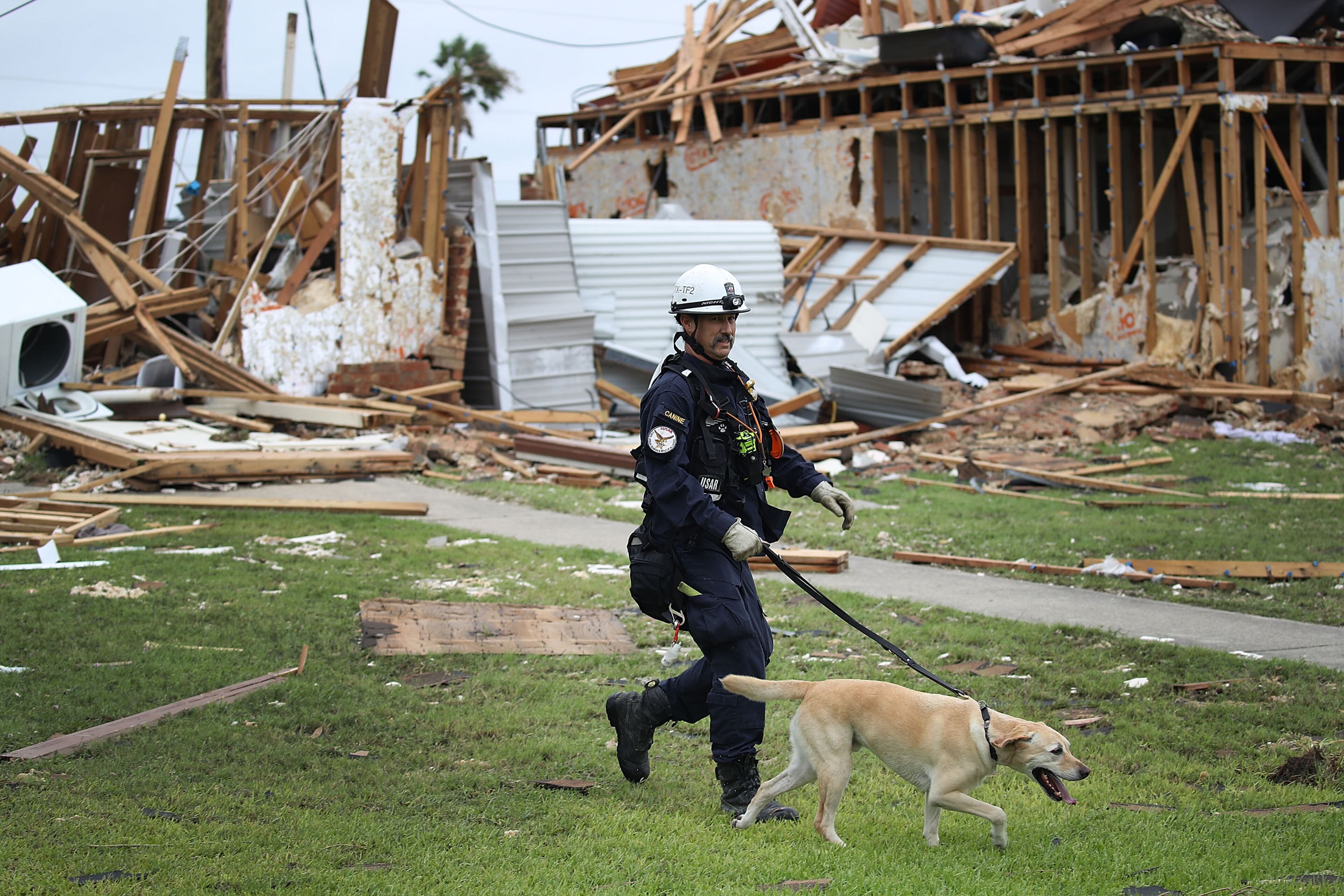 ROCKPORT, TX - AUGUST 27: Robert Grant and Rocky from the Texas Task Force 2 search and rescue team work through a destroyed apartment complex trying to find anyone that still may be in the apartment complex after Hurricane Harvey passed through on August 27, 2017 in Rockport, Texas. Harvey made landfall shortly after 11 p.m. Friday, just north of Port Aransas as a Category 4 storm and is being reported as the strongest hurricane to hit the United States since Wilma in 2005. Forecasts call for as much as 30 inches of rain to fall in the next few days. (Photo by Joe Raedle/Getty Images)