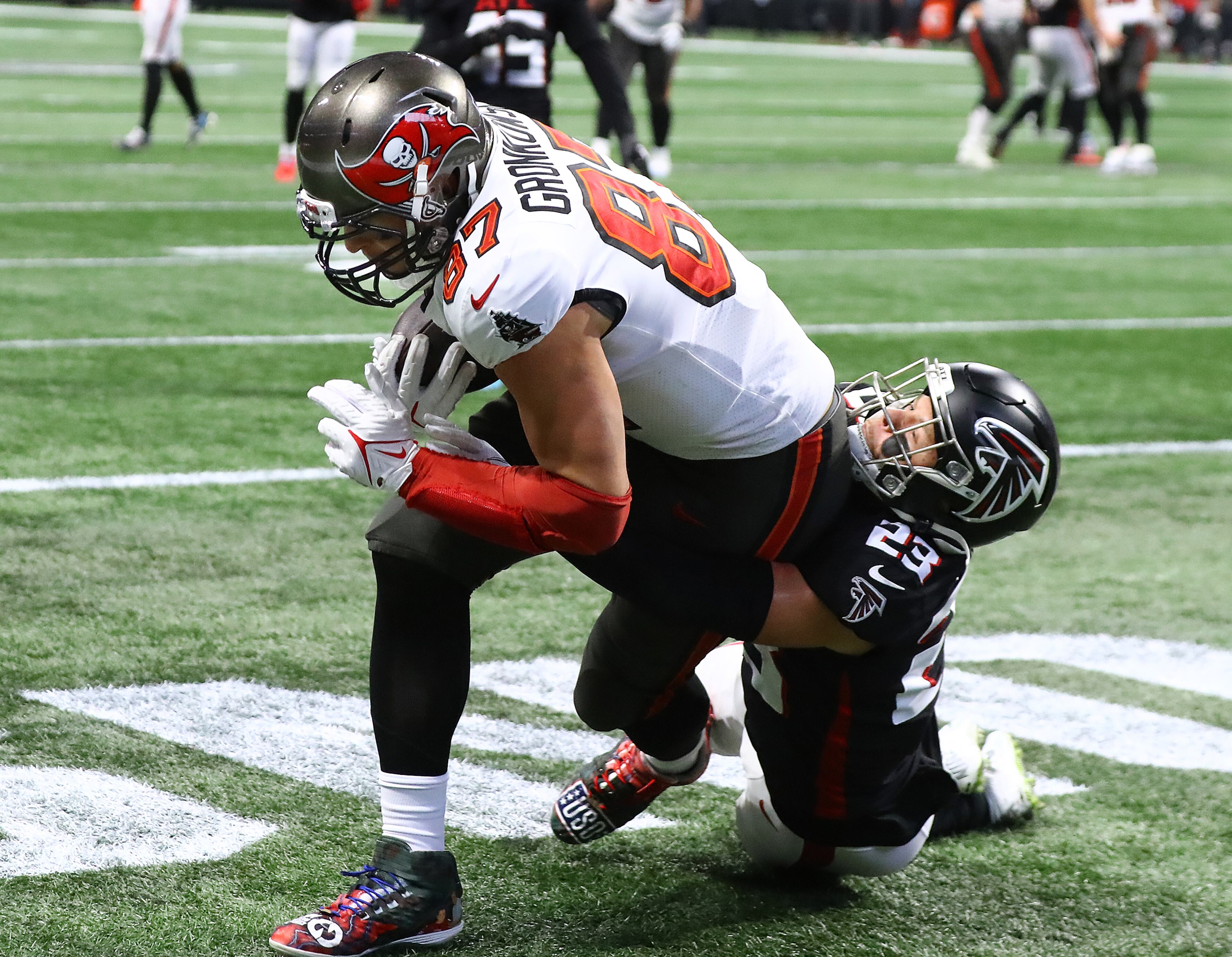 Buccaneers tight end Rob Gronkowski gets in the end zone for his second touchdown reception of the day from Tom Brady pulling along Falcons safety Erik Harris for a 27-17 lead during the third quarter. (Curtis Compton / Curtis.Compton@ajc.com)