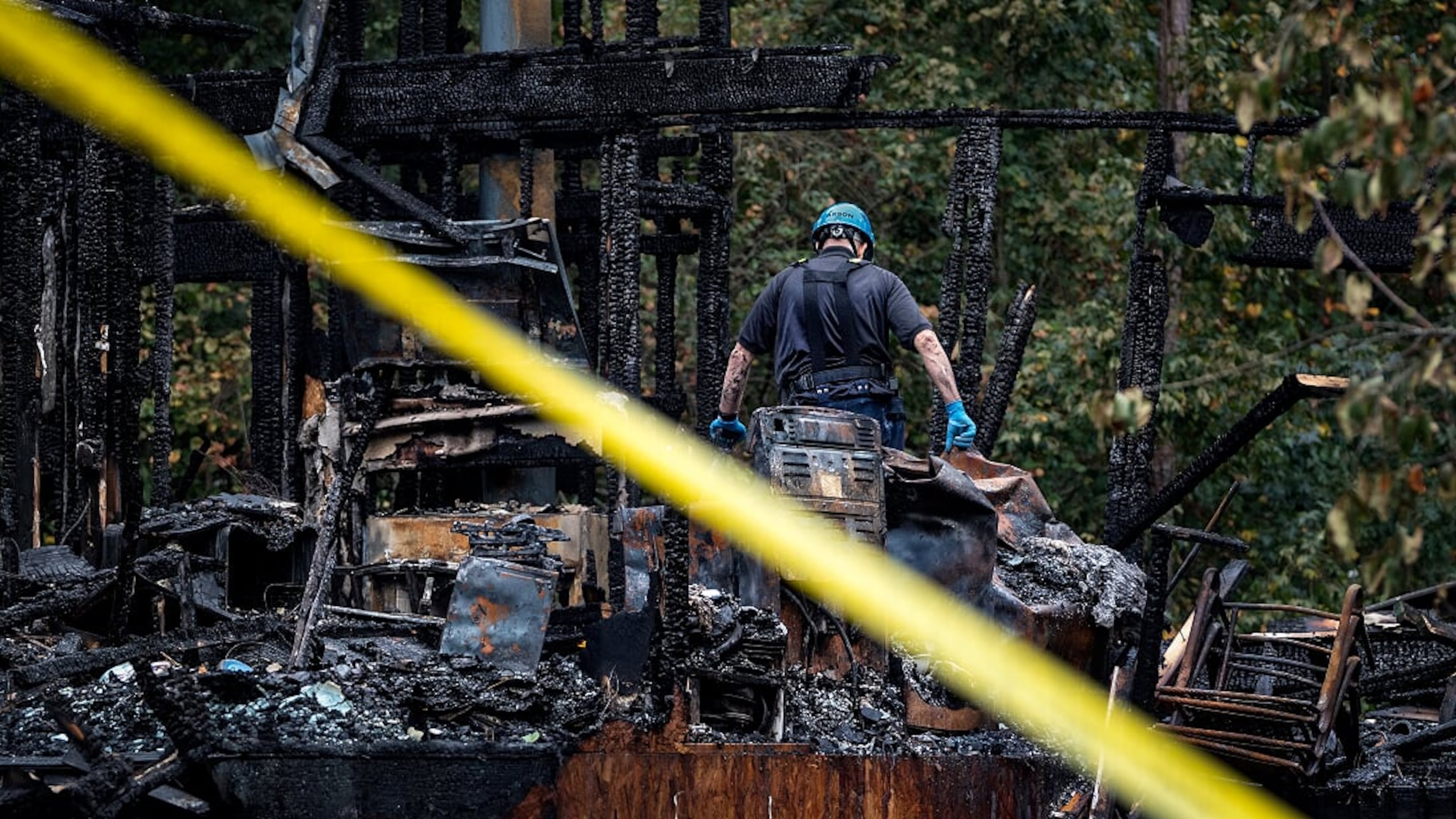 A man sifts through the rubble of a Forsyth County home that burned down, killing two children.