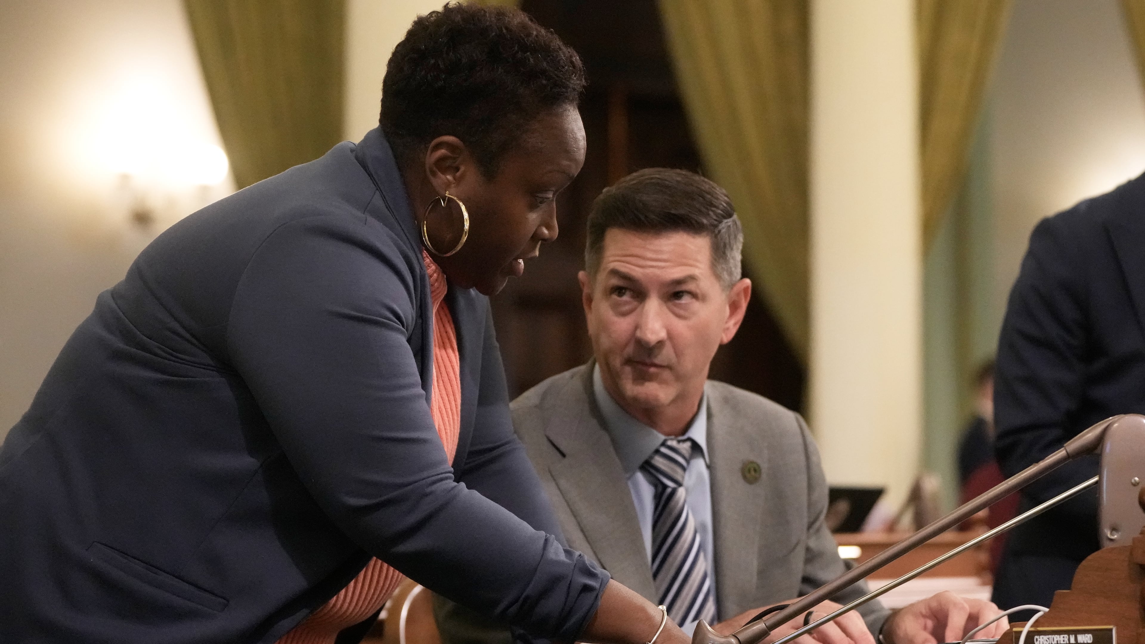 Assemblymember LaShae Sharp-Collins, left, talks with Assemblymember Christopher Ward during an Assembly session at the Capitol, Monday, Aug. 31, 2026, in Sacramento, Calif. (AP Photo/Jeff Chiu)