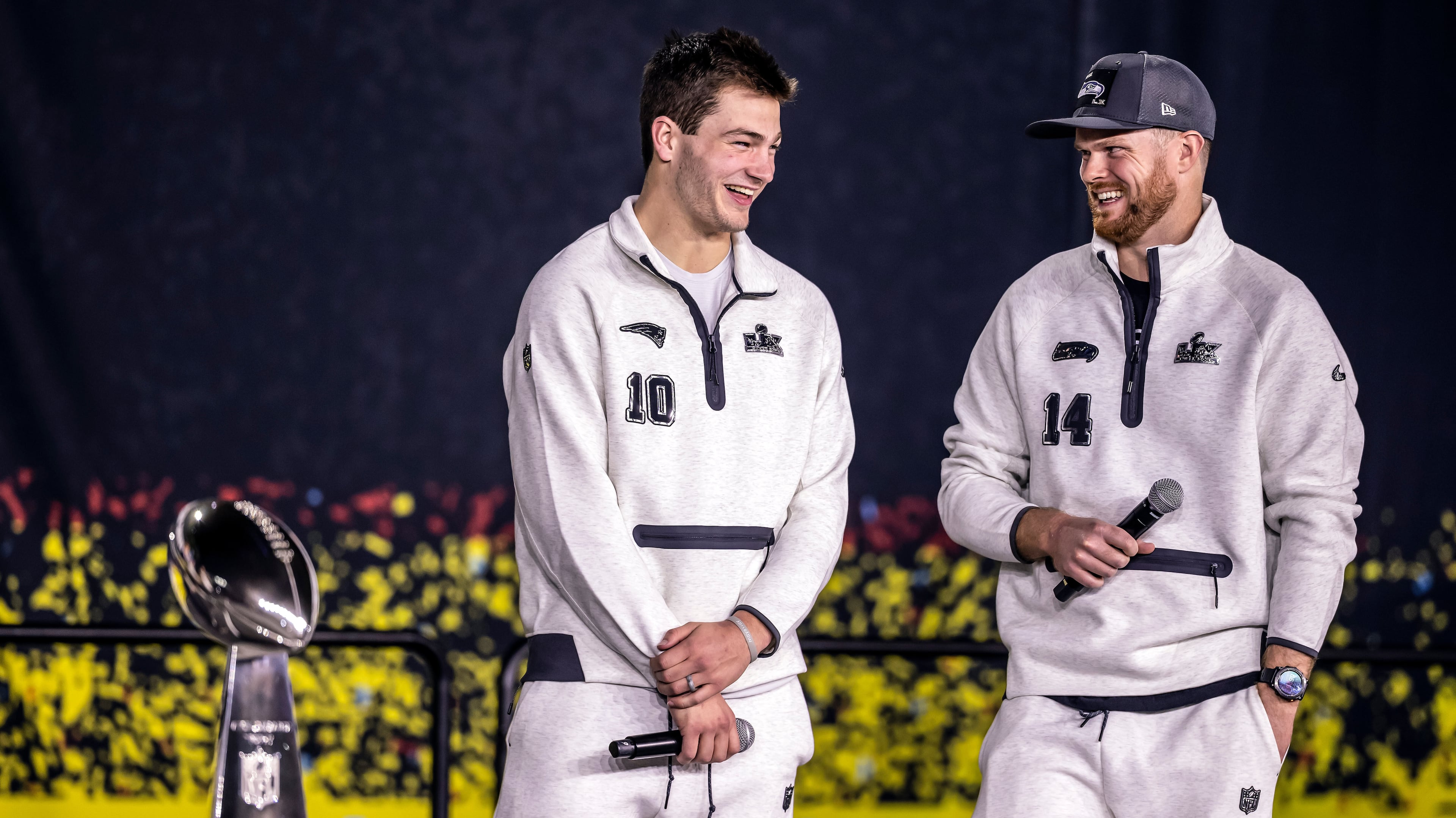 New Englad Patriots quarterback Drake Maye, left, and Seattle Seahawks quarterback Sam Darnold, right, smile on stage with the Lombardi Trophy during the NFL Super Bowl Opening Night, Monday, Feb. 2, 2026, in San Jose, Calif., ahead of the Super Bowl 60 football game between the New England Patriots and the Seattle Seahawks. (Carlos Avila Gonzalez/San Francisco Chronicle via AP)