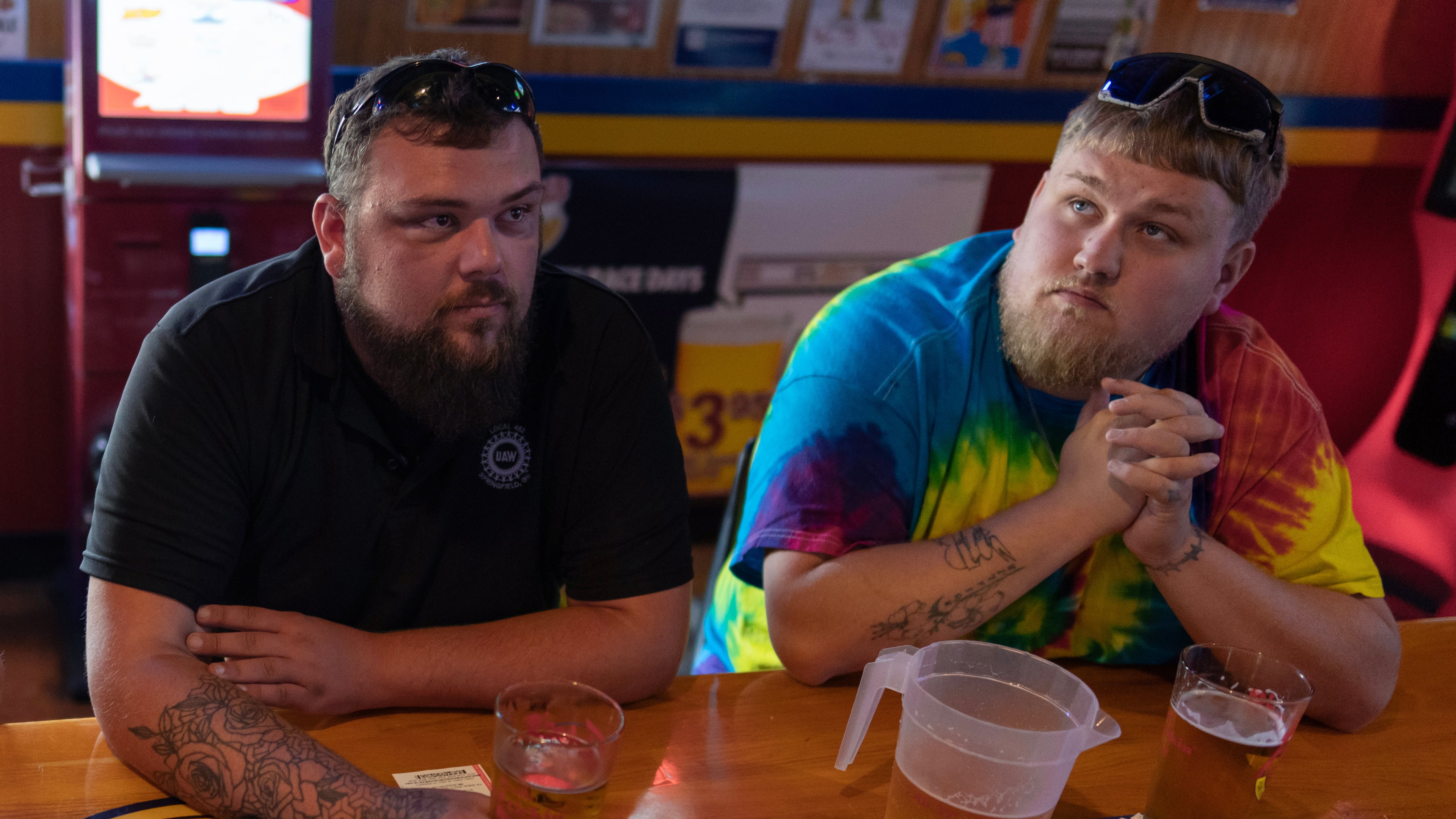 UAW Local 402 members Chaz Graham, left, and Kyle Bos, right, share a beer at Fricker's restaurant and bar in Springfield, Ohio, on Wednesday, Sept. 30, 2026, on old Navistar's last day at its Springfield plant. (AP Photo/Carolyn Kaster)