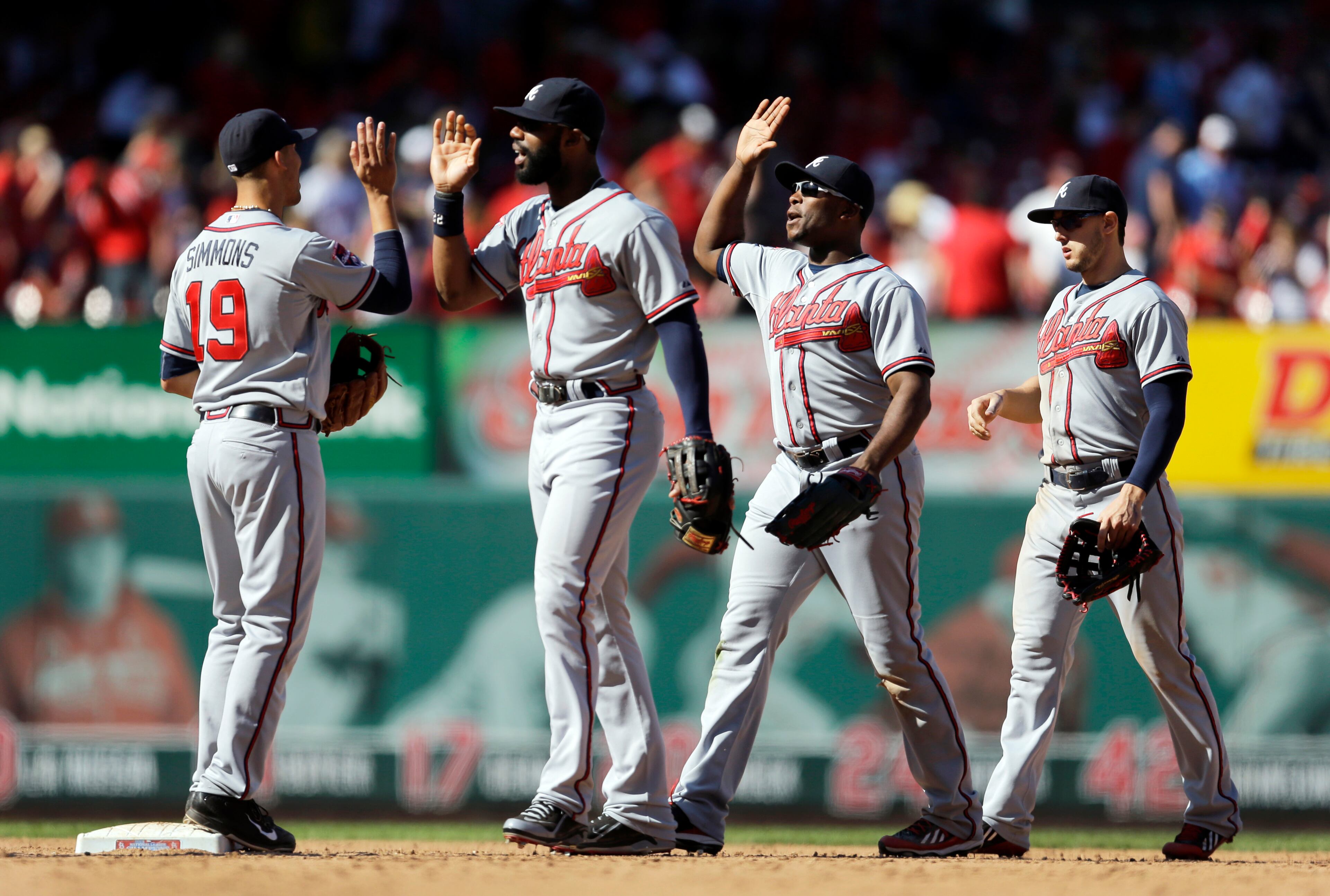 Atlanta Braves, from left to right, Andrelton Simmons, Jason Heyward, Justin Upton and Jordan Schafer celebrate after defeating the St. Louis Cardinals 6-5 in a baseball game Sunday, May 18, 2014, in St. Louis. (AP Photo/Jeff Roberson)
