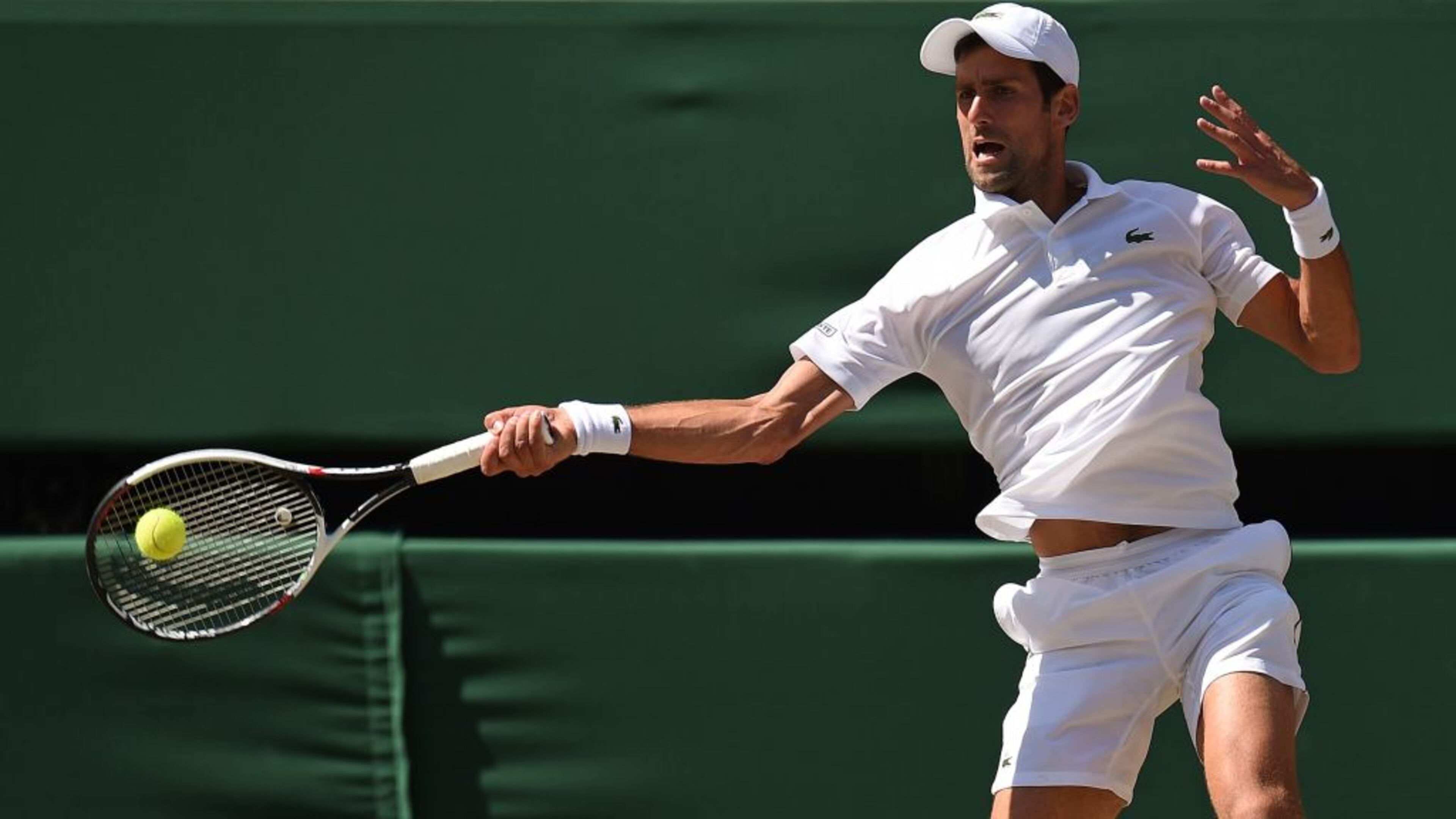 Serbia's Novak Djokovic returns a forehand to South Africa's Kevin Anderson in their men's singles final match at Wimbledon .